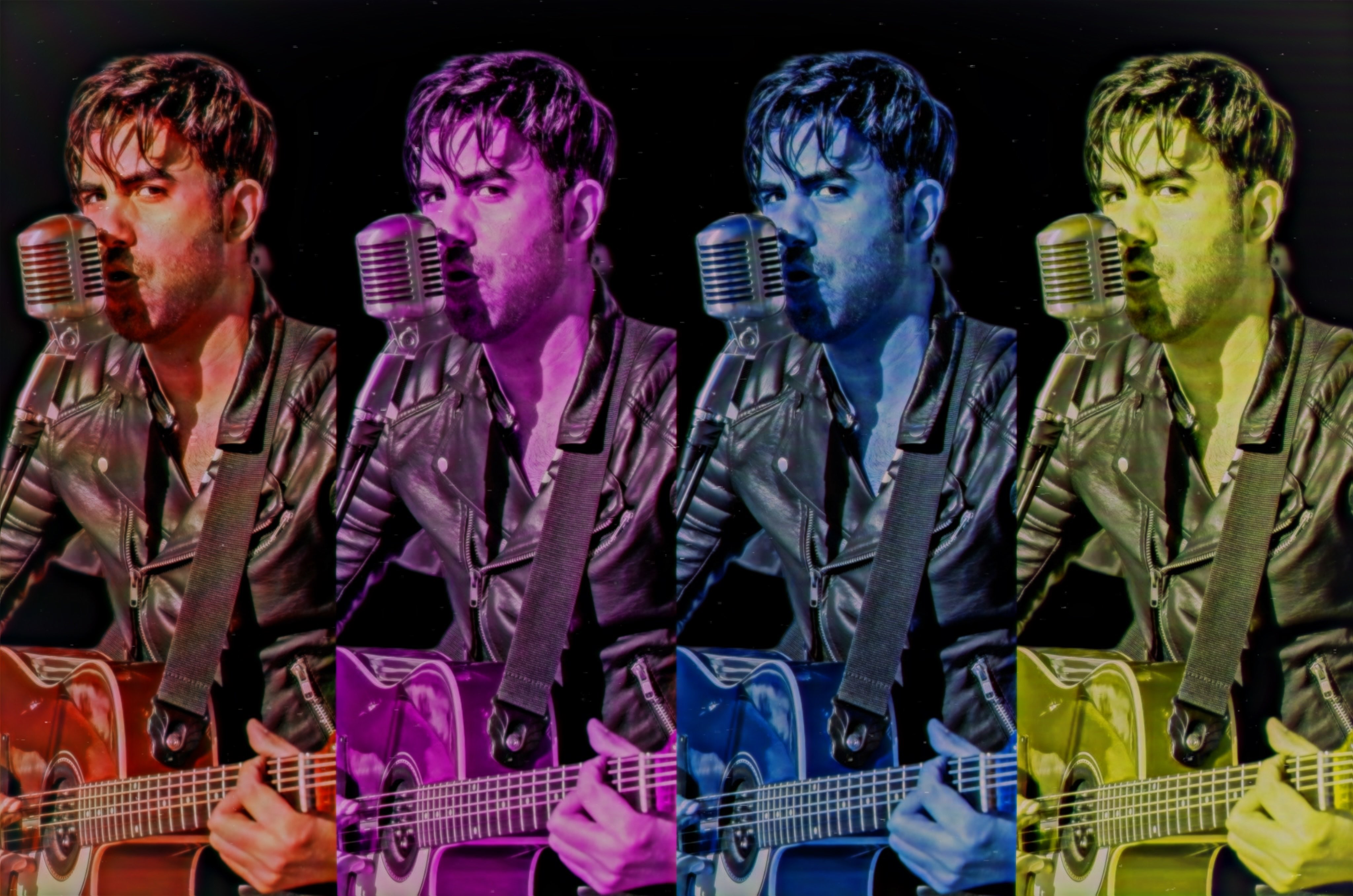 a man is holding a guitar and singing into a microphone