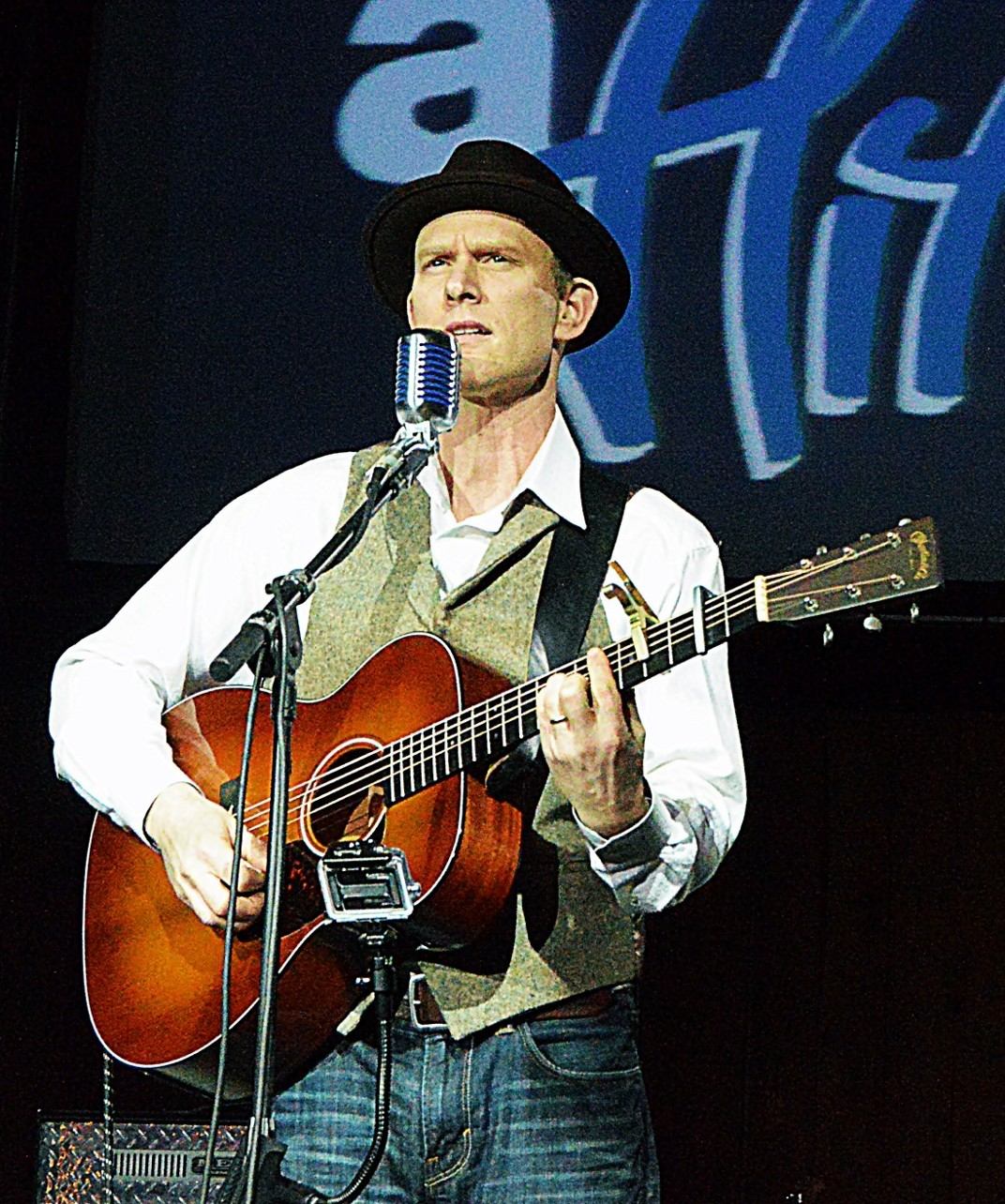 a man holding an acoustic guitar