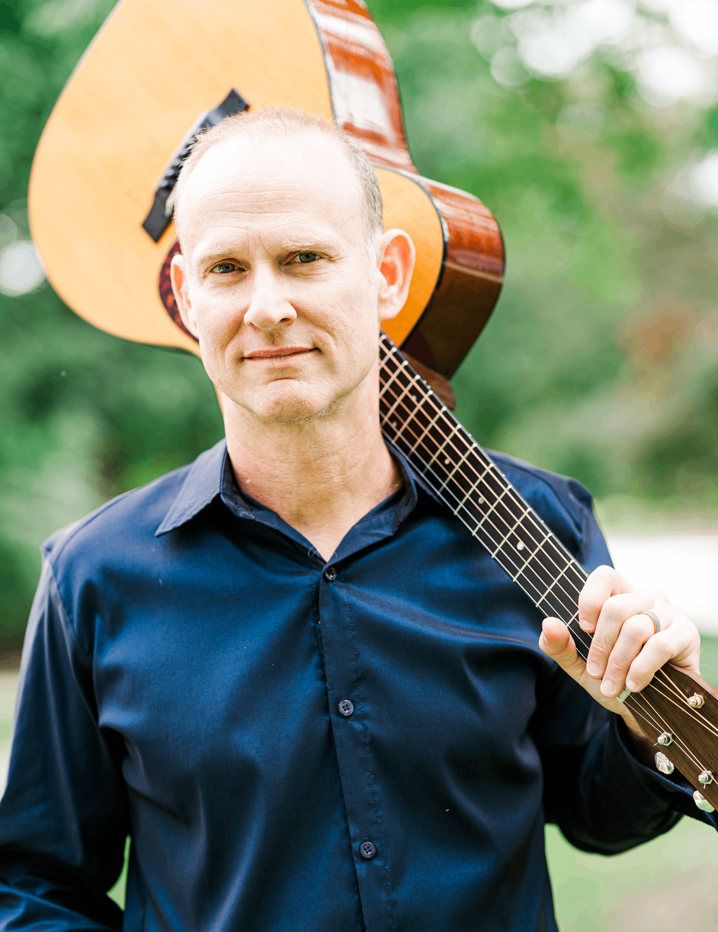 a man holding an acoustic guitar