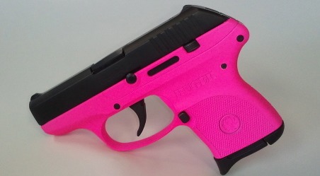 32) "kisssssss": a pink and black pistol on a white surface