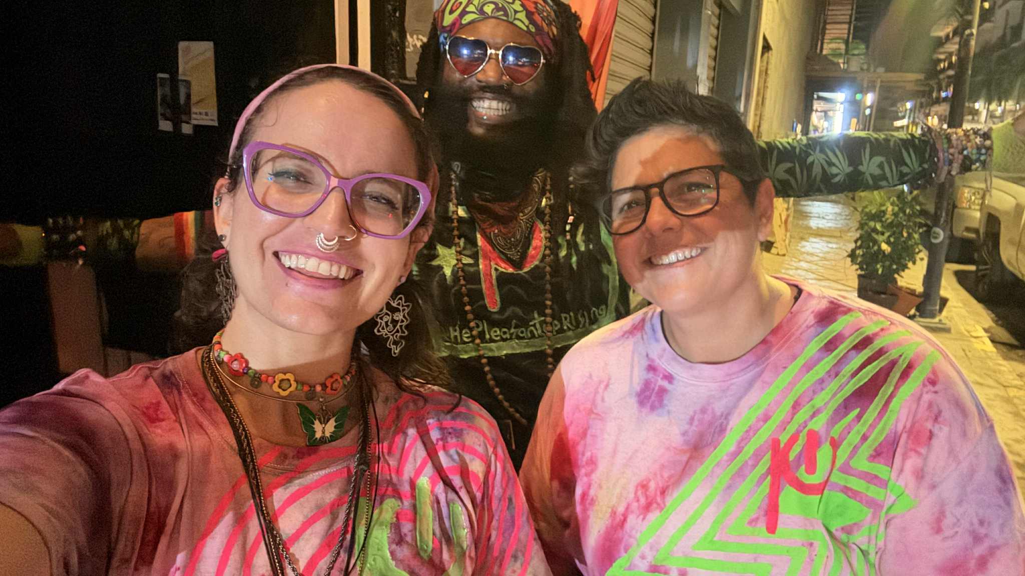 two women in tie dye shirts posing for a photo