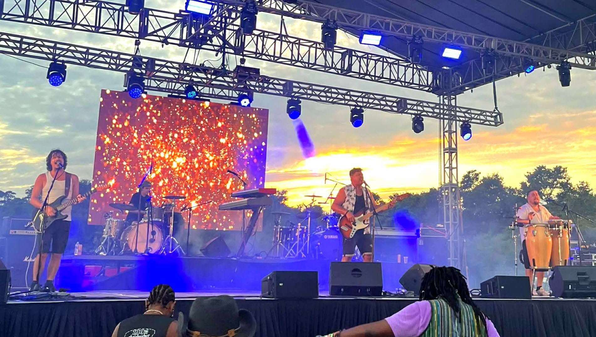 34) the big time: a group of people on stage at an outdoor concert