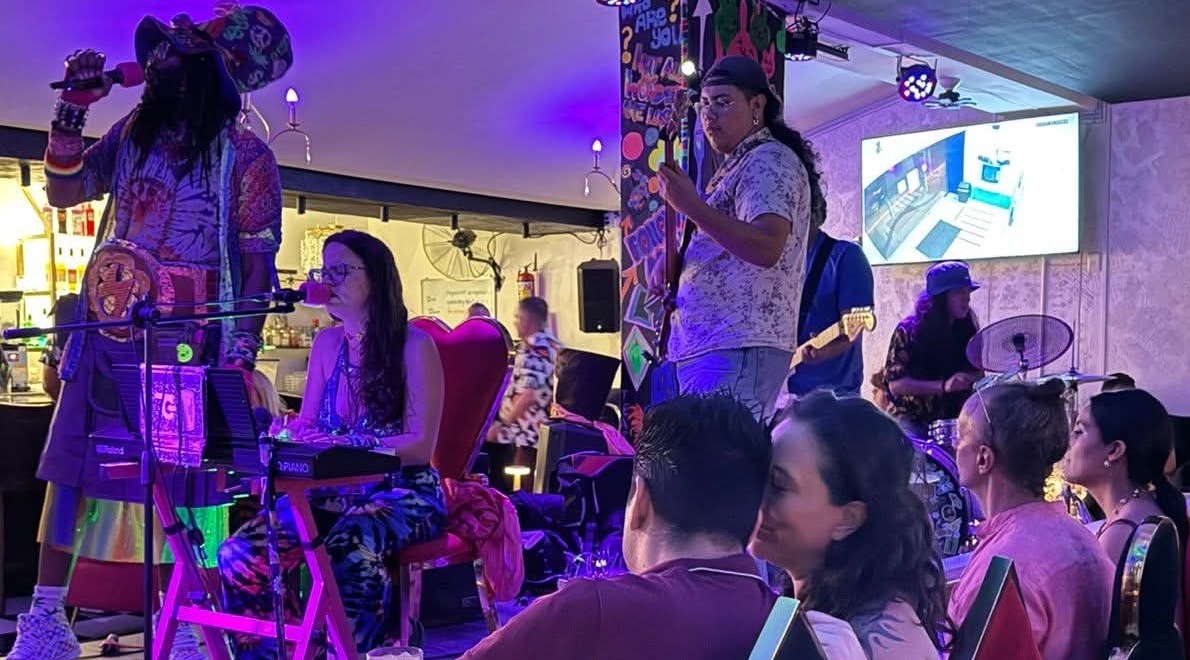 a group of people sitting at a table and listening to music