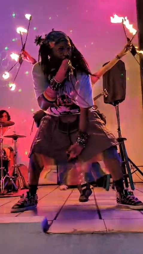 a group of people performing on stage with fire torches