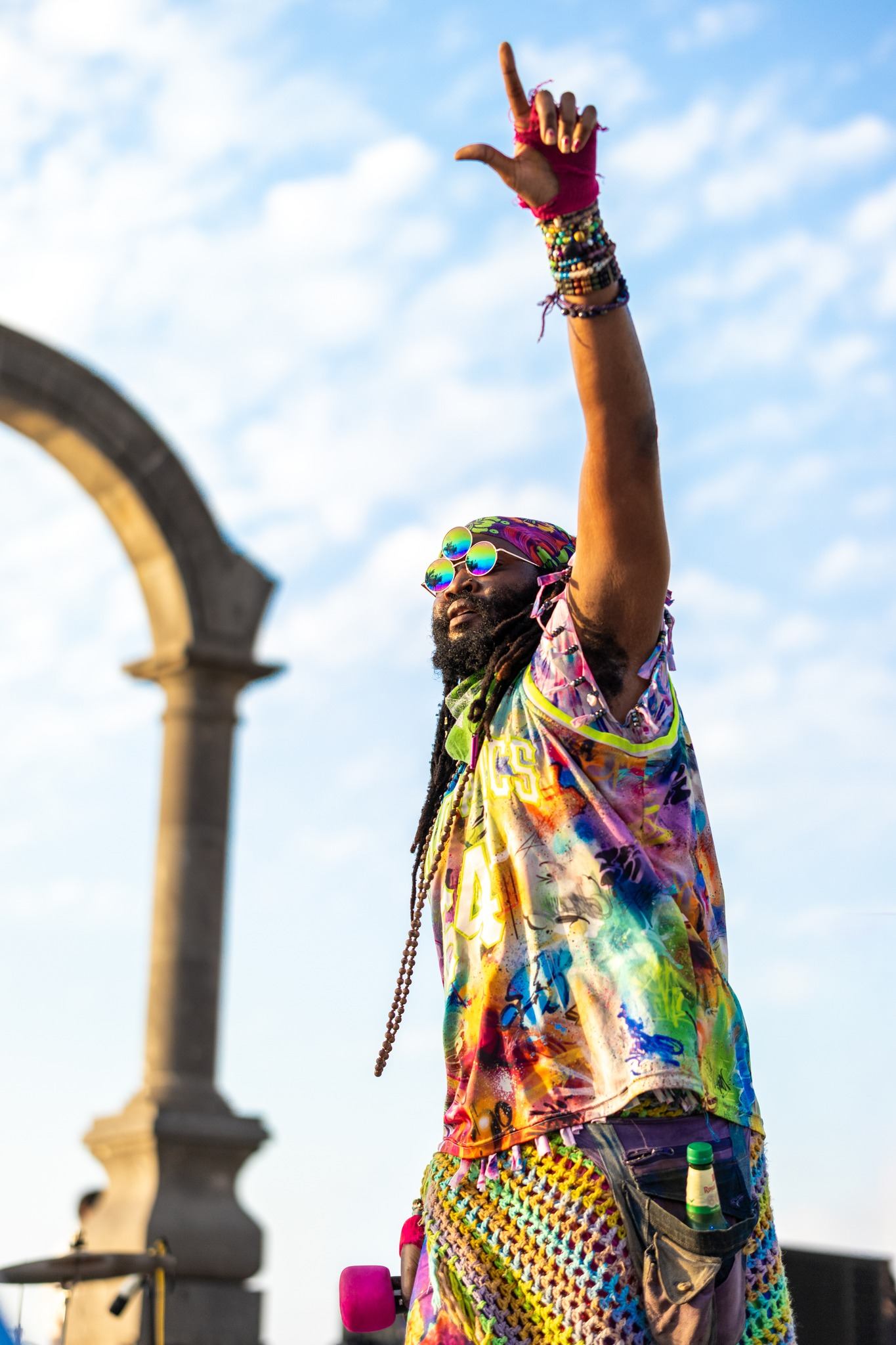 a man in a colorful outfit is waving his arms in the air