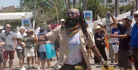 38) re: "demonstrations": a man with dreadlocks standing in front of a crowd