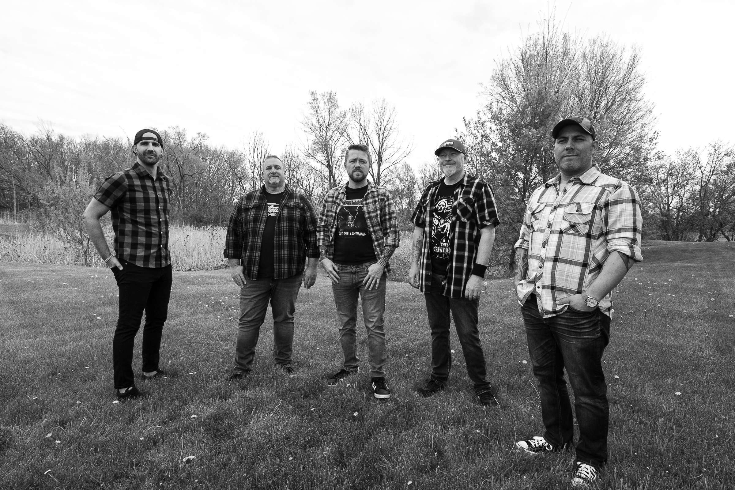 a black and white photo of a group of men standing in a field