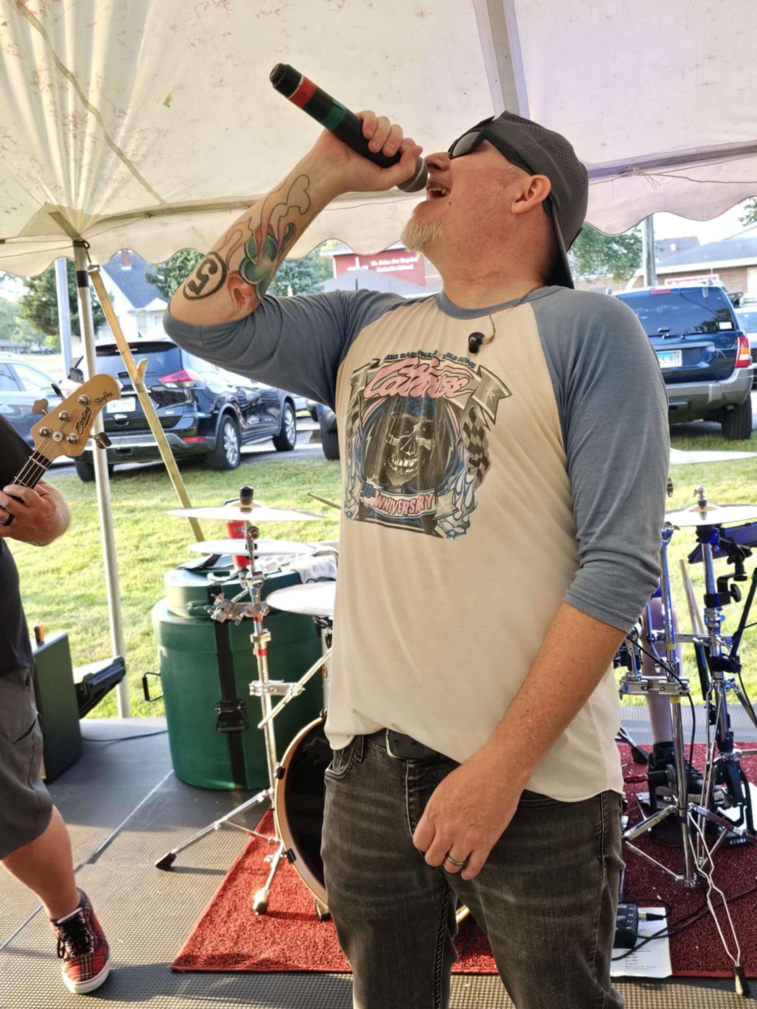 a man singing into a microphone at an outdoor event