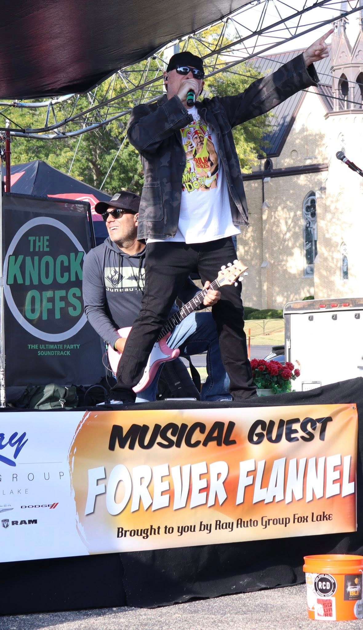 a man singing on stage at an outdoor event