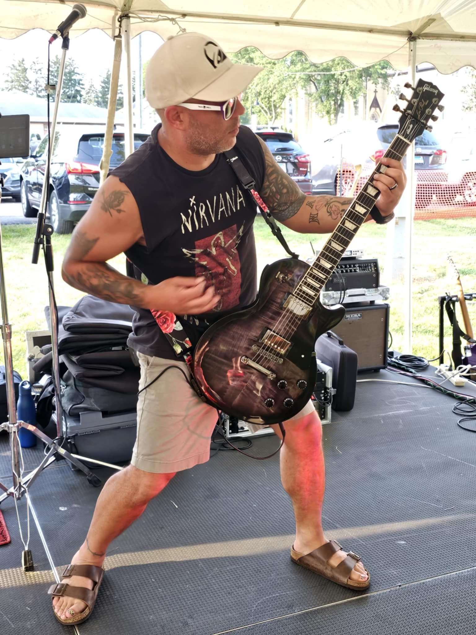 a man playing a guitar in front of a tent