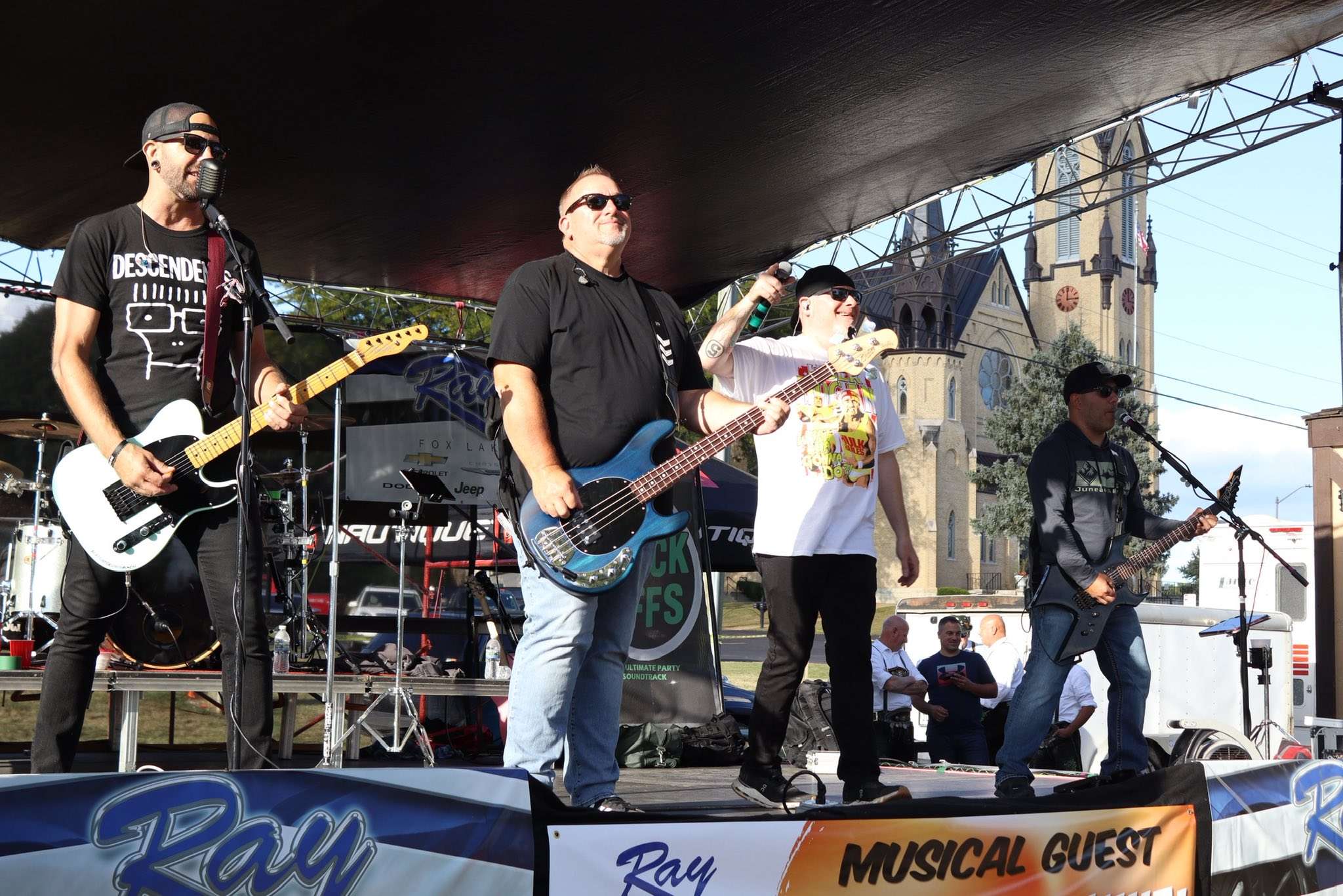 a group of men standing on stage at an outdoor event