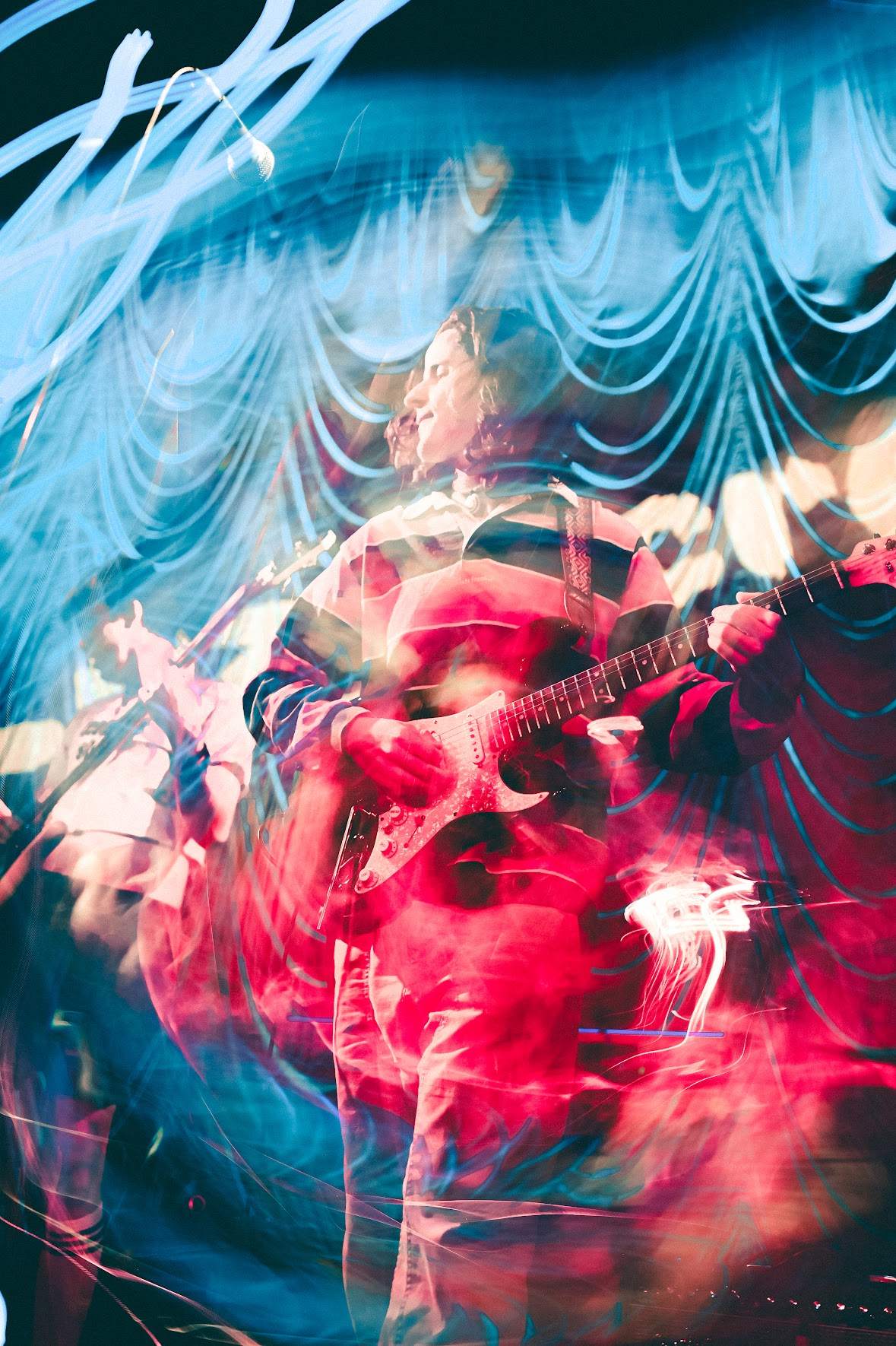 a blurry image of a man playing a guitar