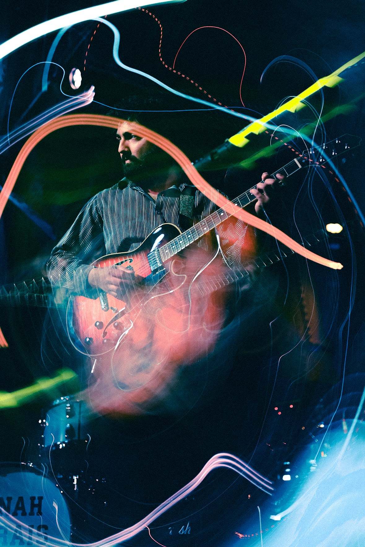 a man playing a guitar in a dark room