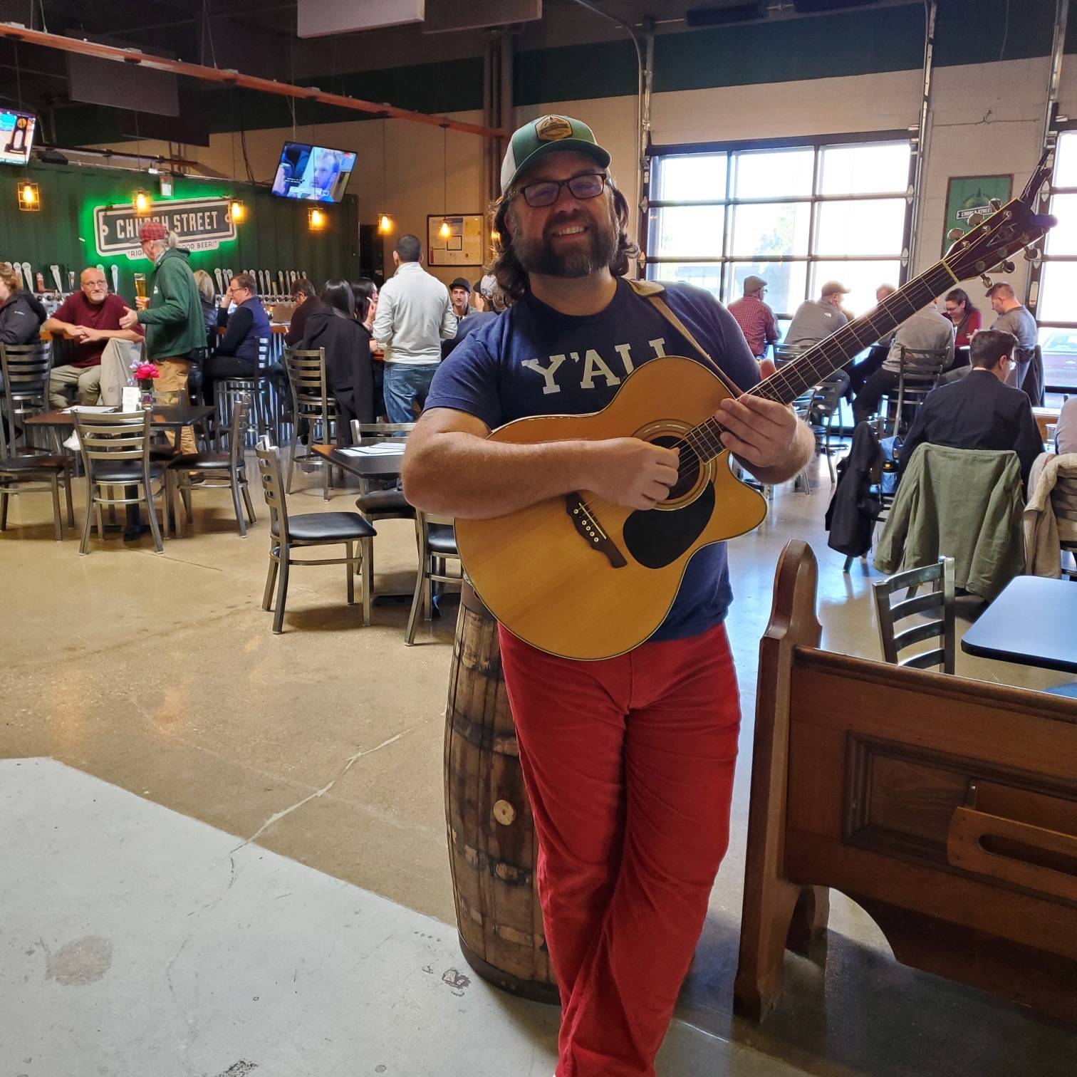 a man playing an acoustic guitar in a bar