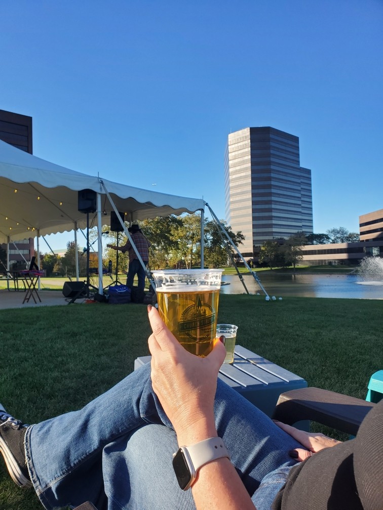 a woman is sitting in a lawn chair with a beer in her hand