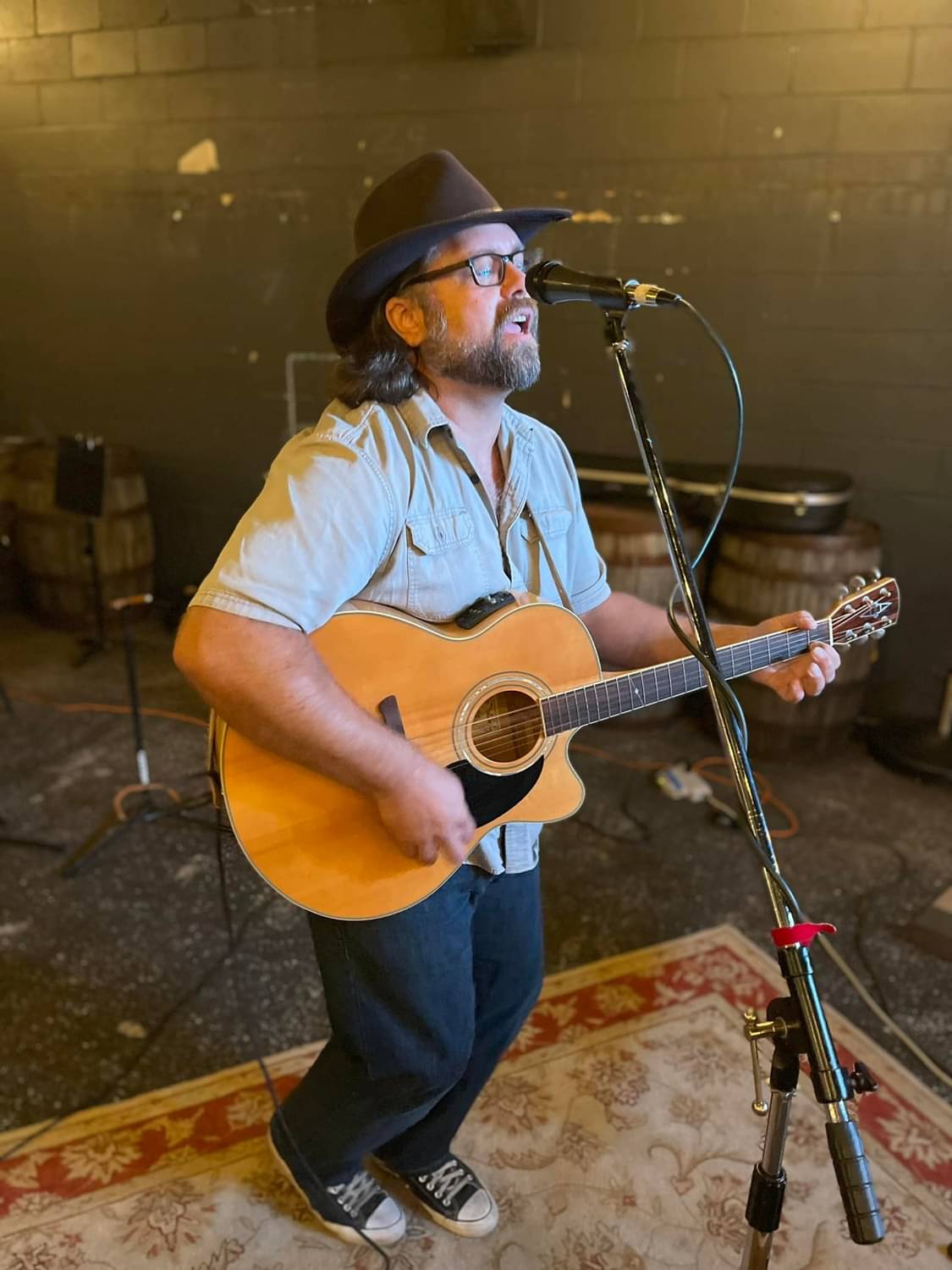 a man in a hat playing an acoustic guitar