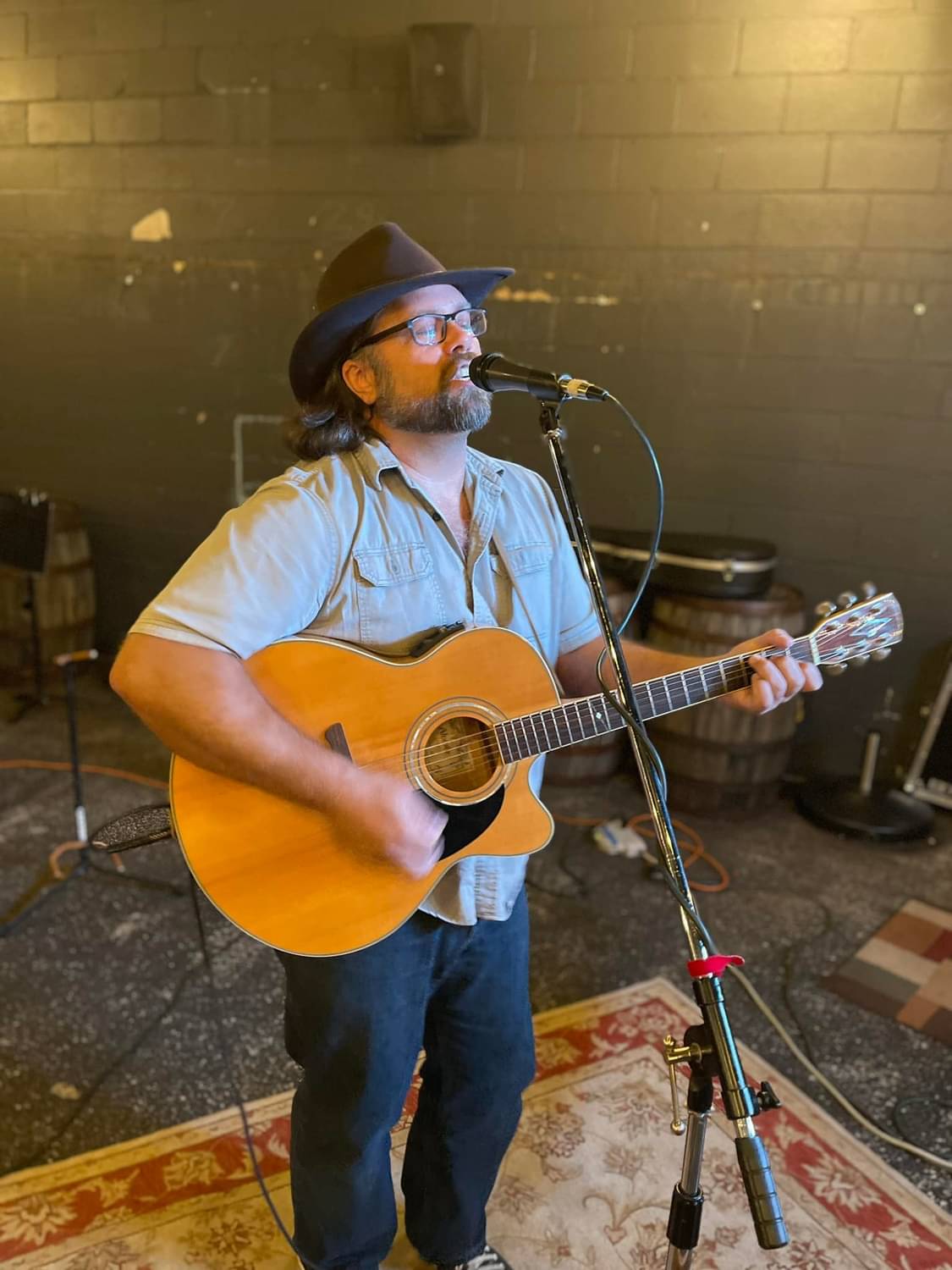 a man in a hat playing an acoustic guitar