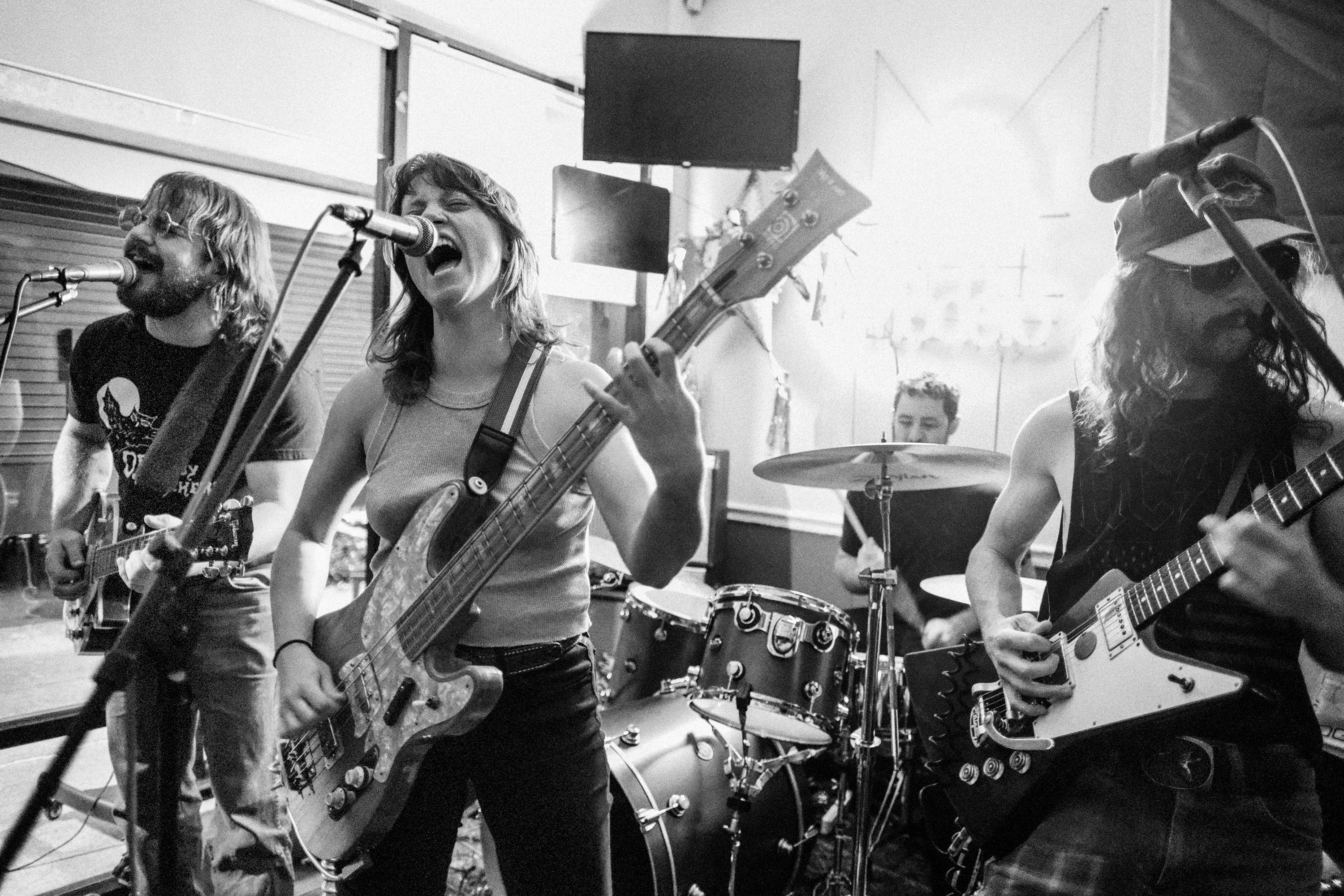 a black and white photo of a group of people playing guitars