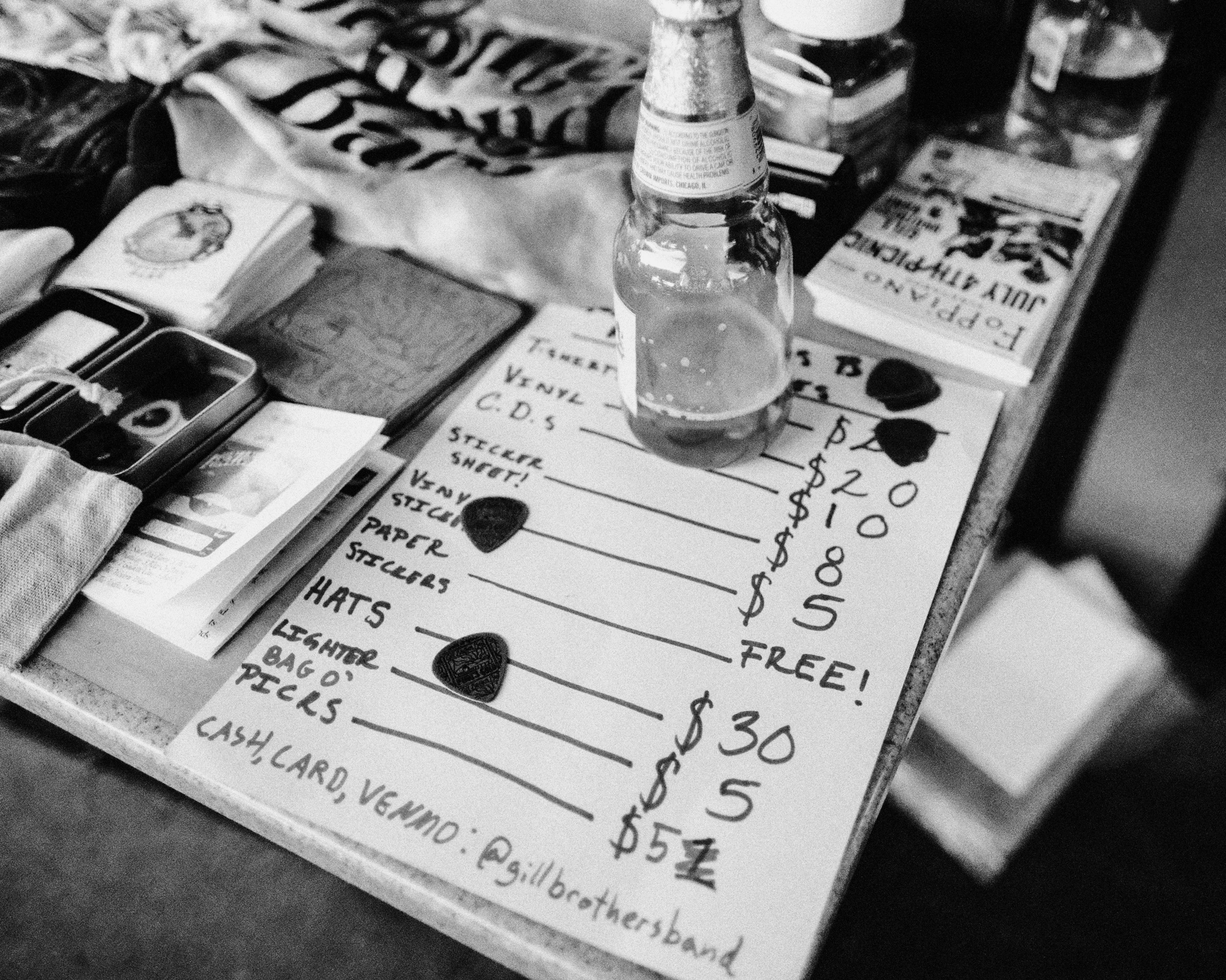 a black and white photo of a table with a bottle of beer on it
