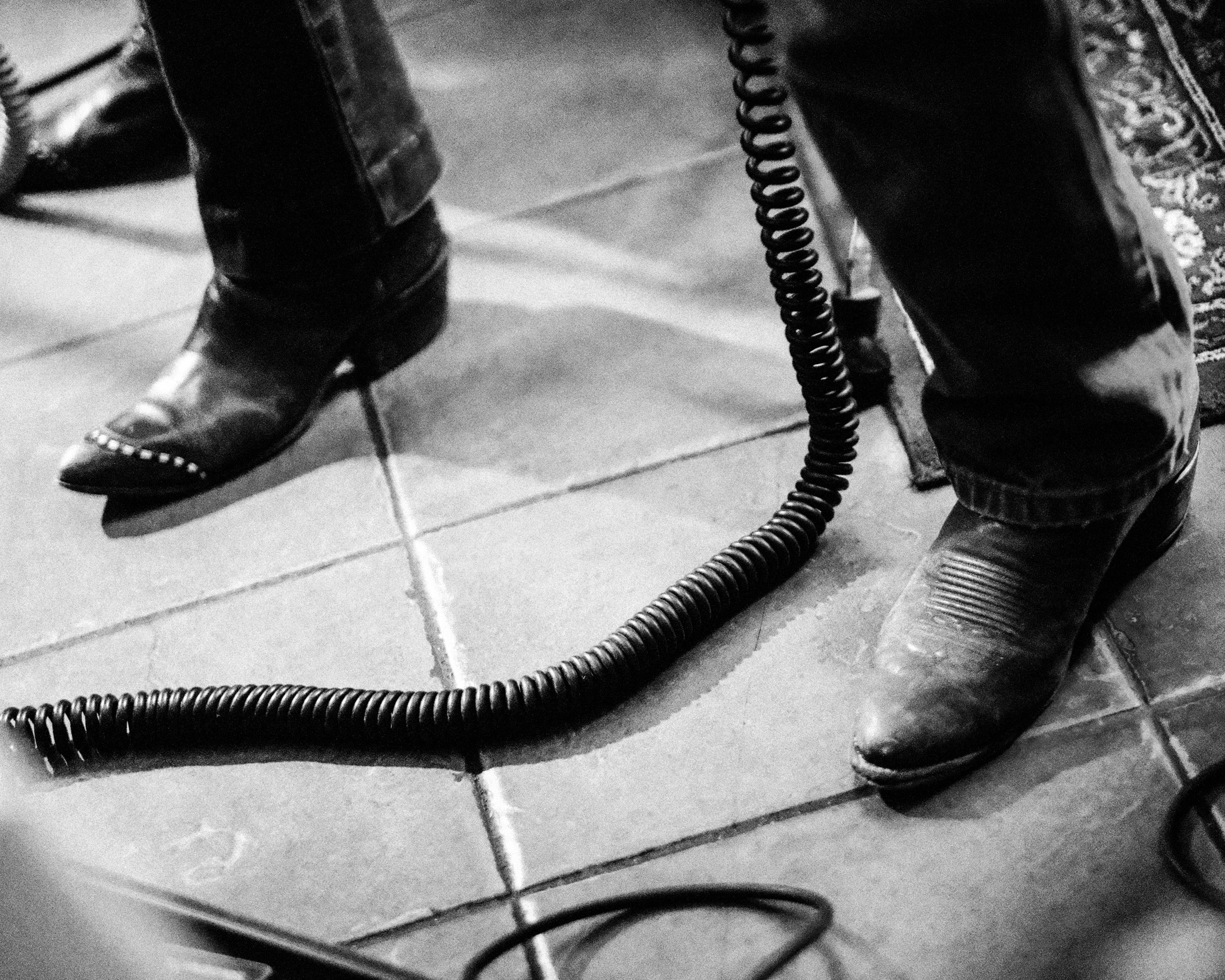 a black and white photo of a pair of cowboy boots