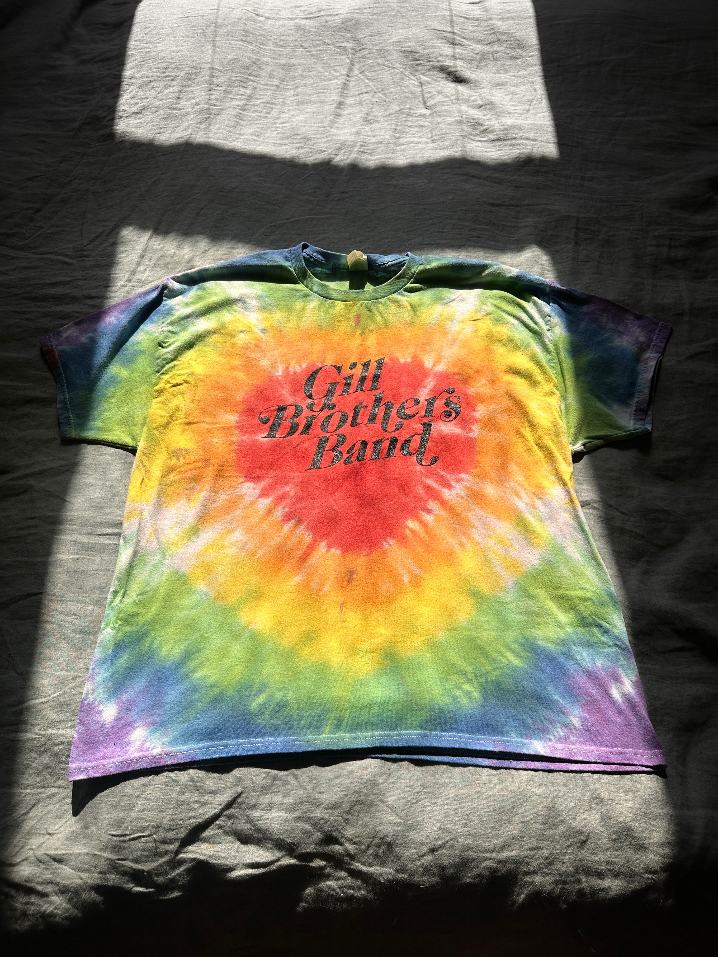 a tie dye t - shirt on a bed