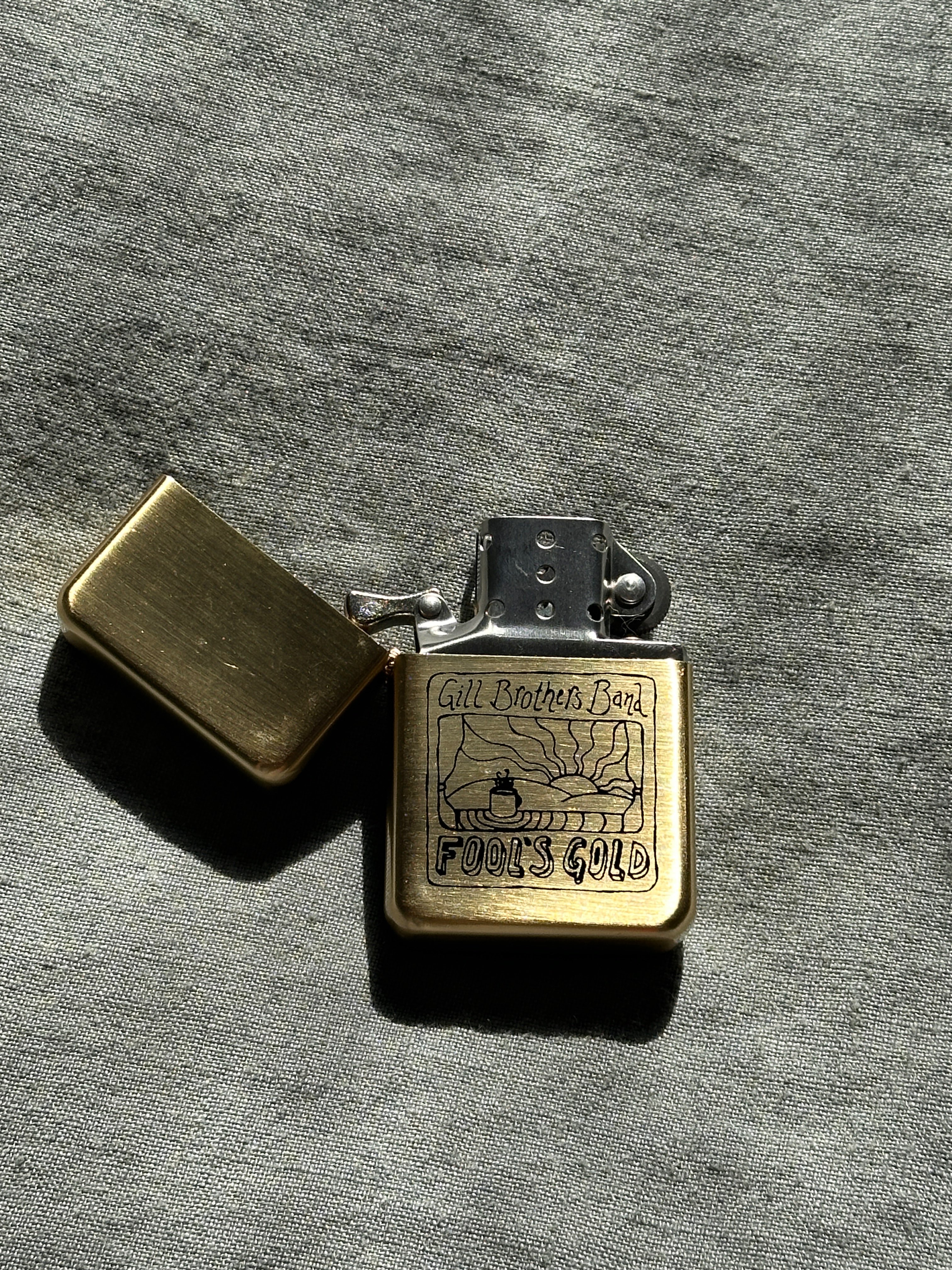 a gold lighter on a grey surface