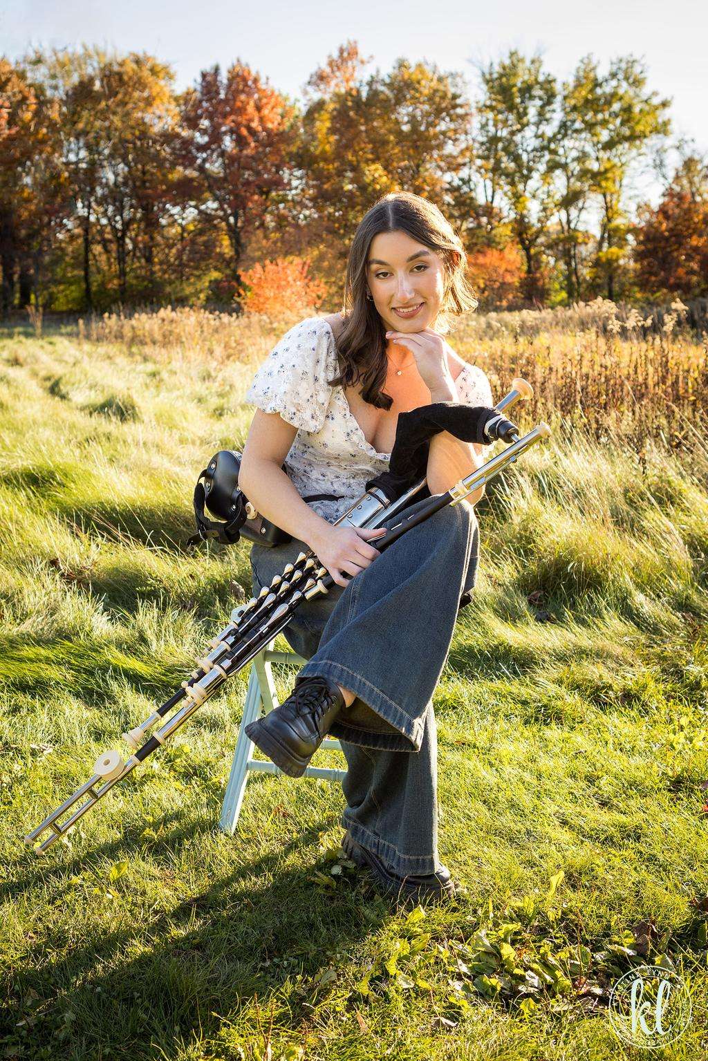 a woman holding a bagpipe in a field