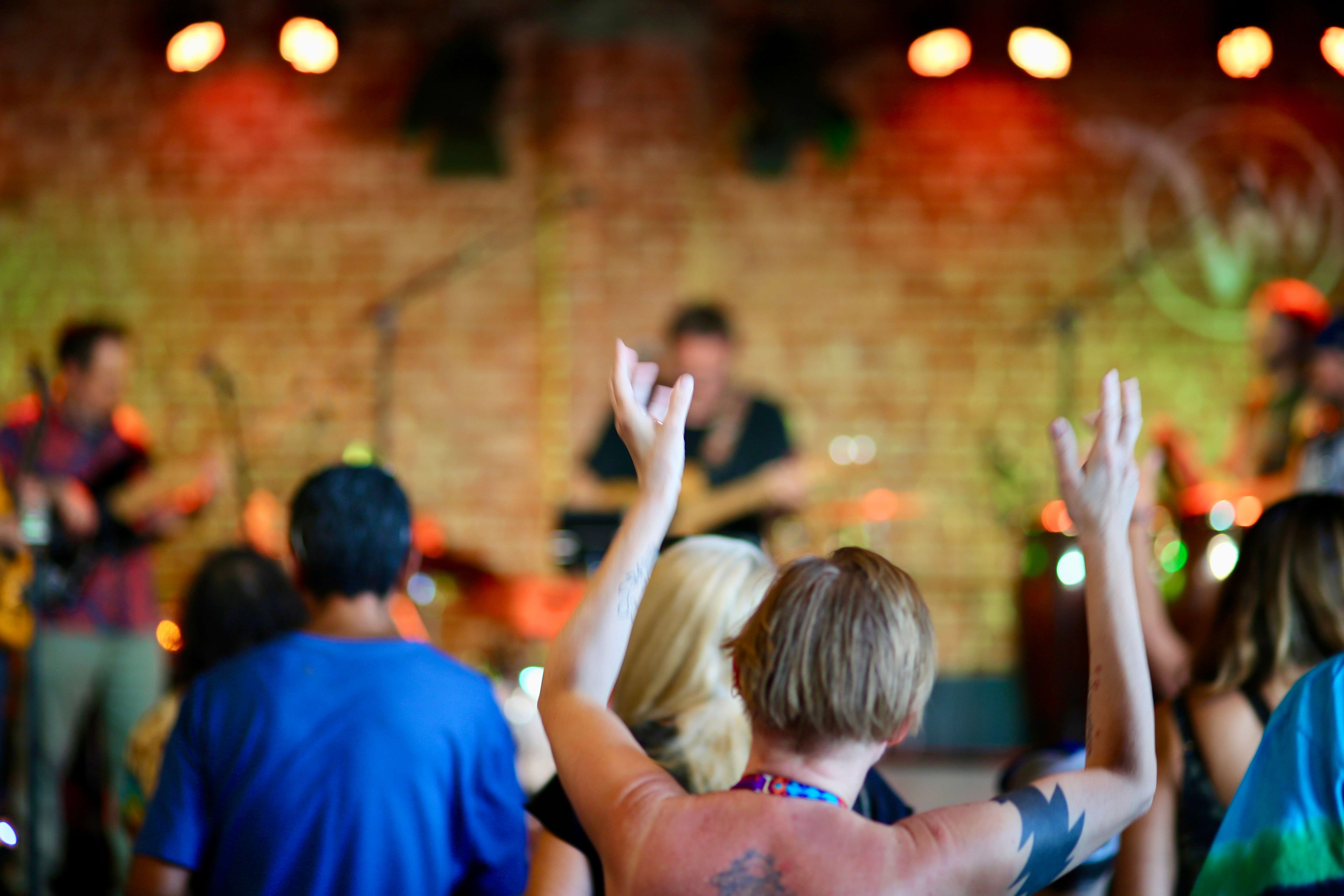 a crowd of people raising their hands at a concert