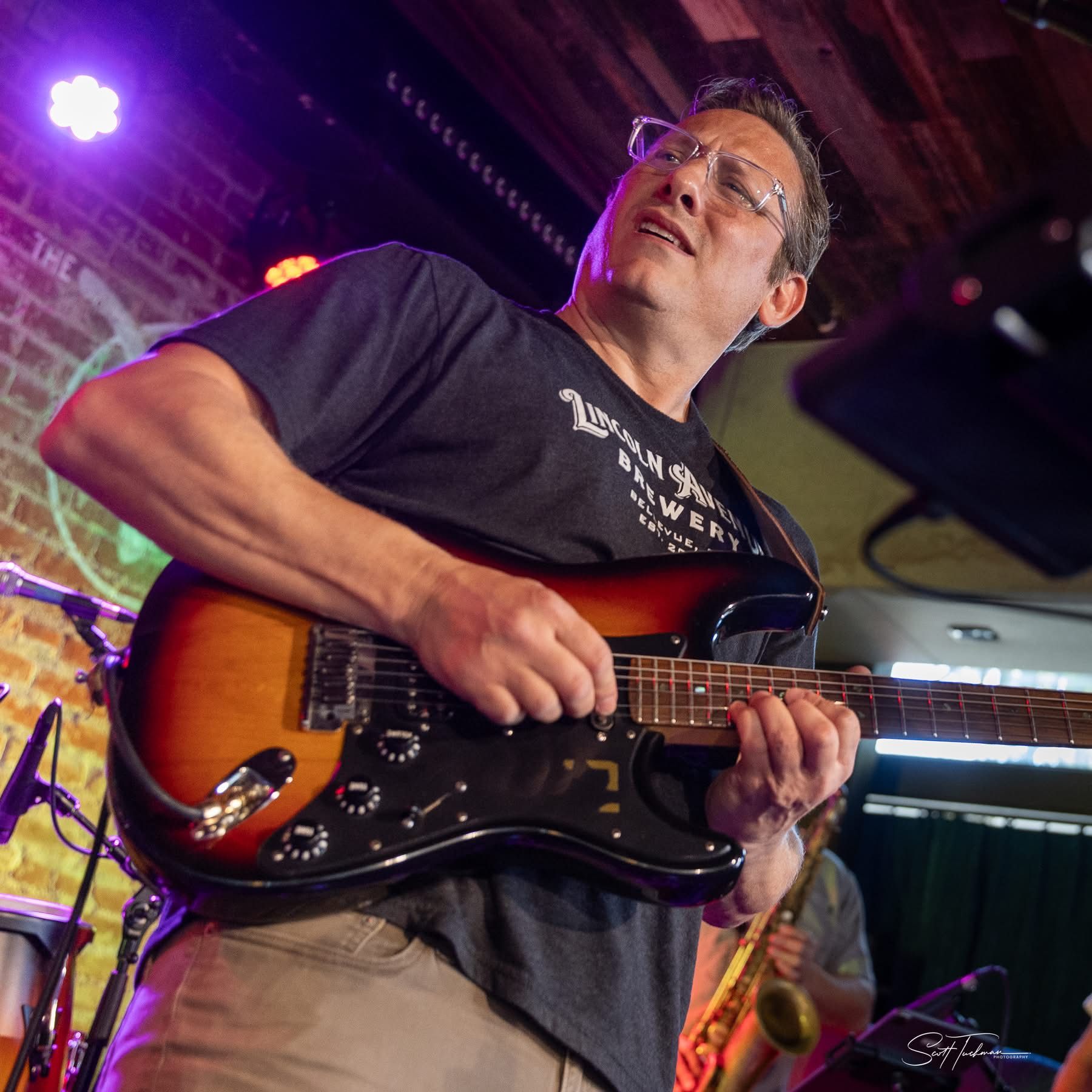 a man playing an electric guitar in front of a microphone