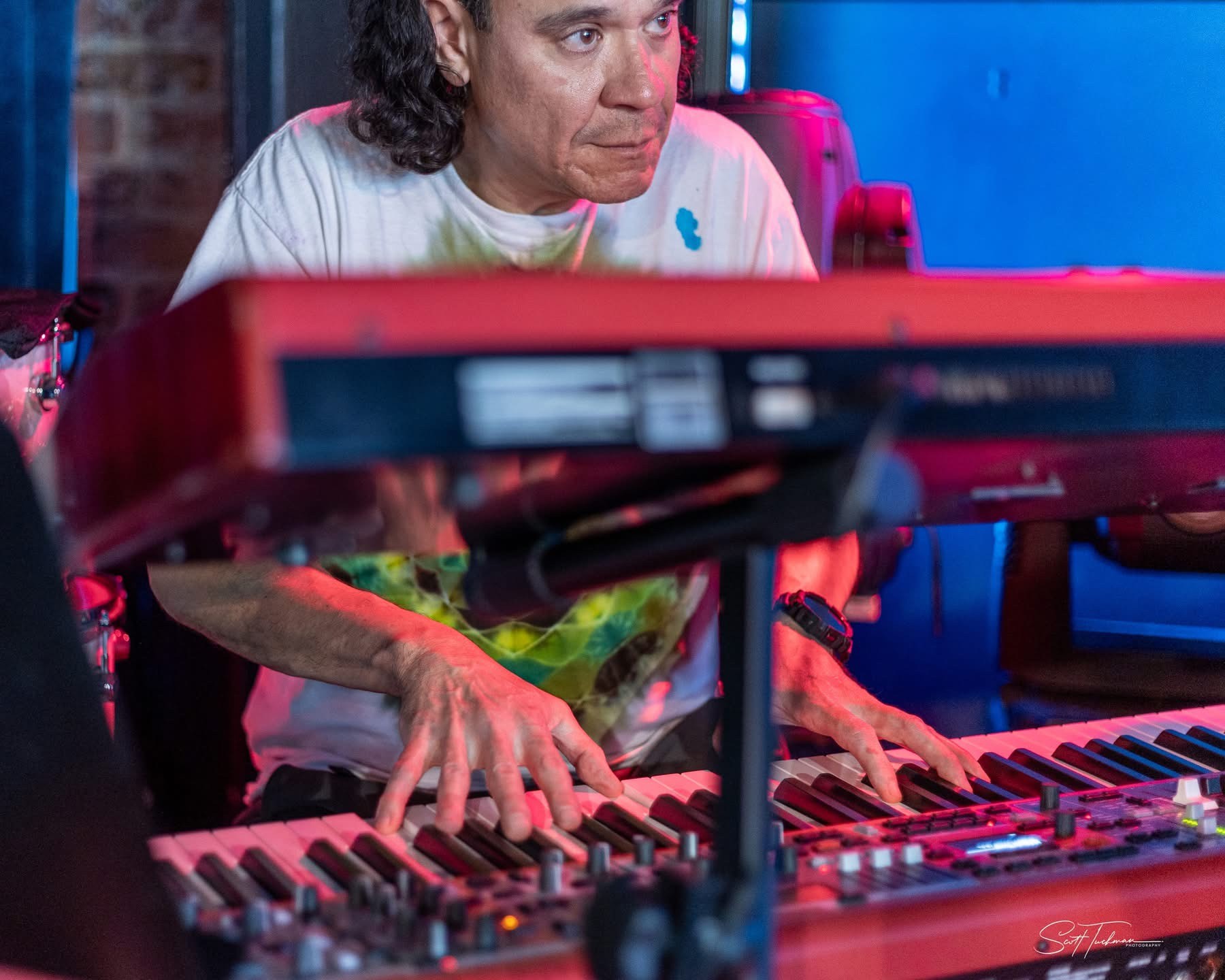 a man with long hair playing a keyboard