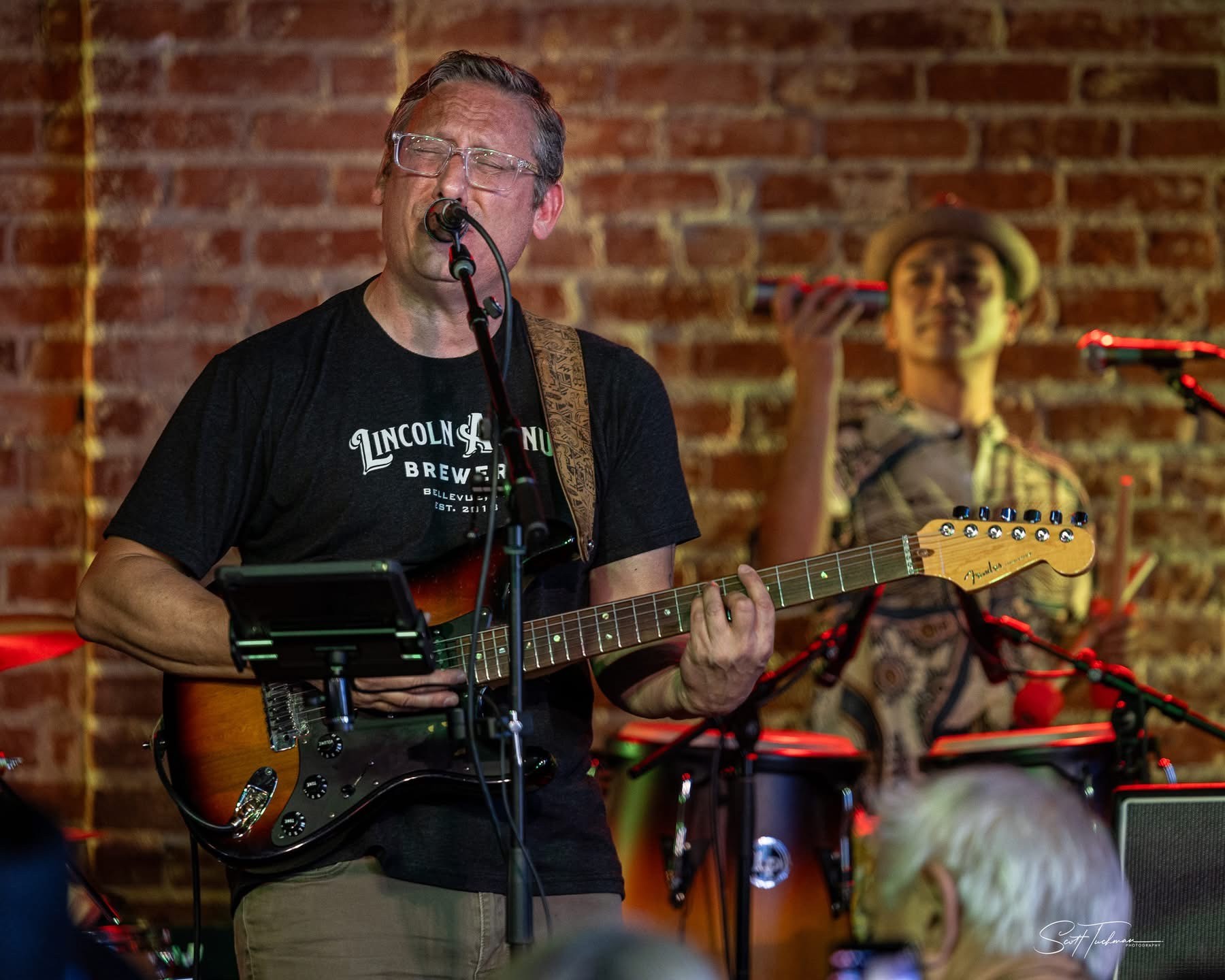 a man playing an electric guitar in front of a microphone