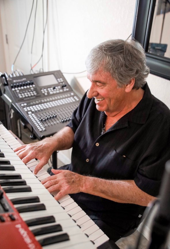 a man playing an electronic keyboard in a recording studio