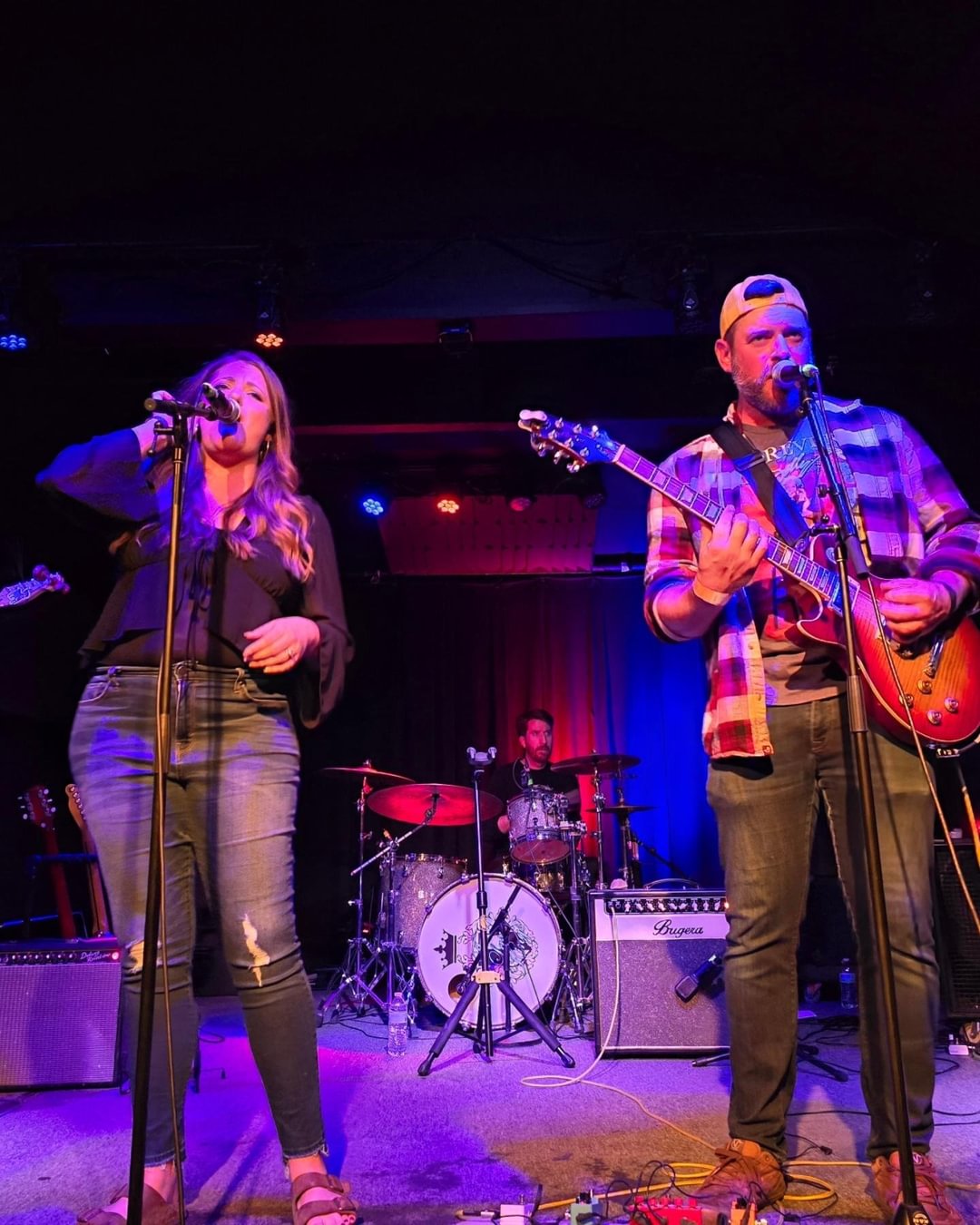 a group of people on stage with guitars and microphones