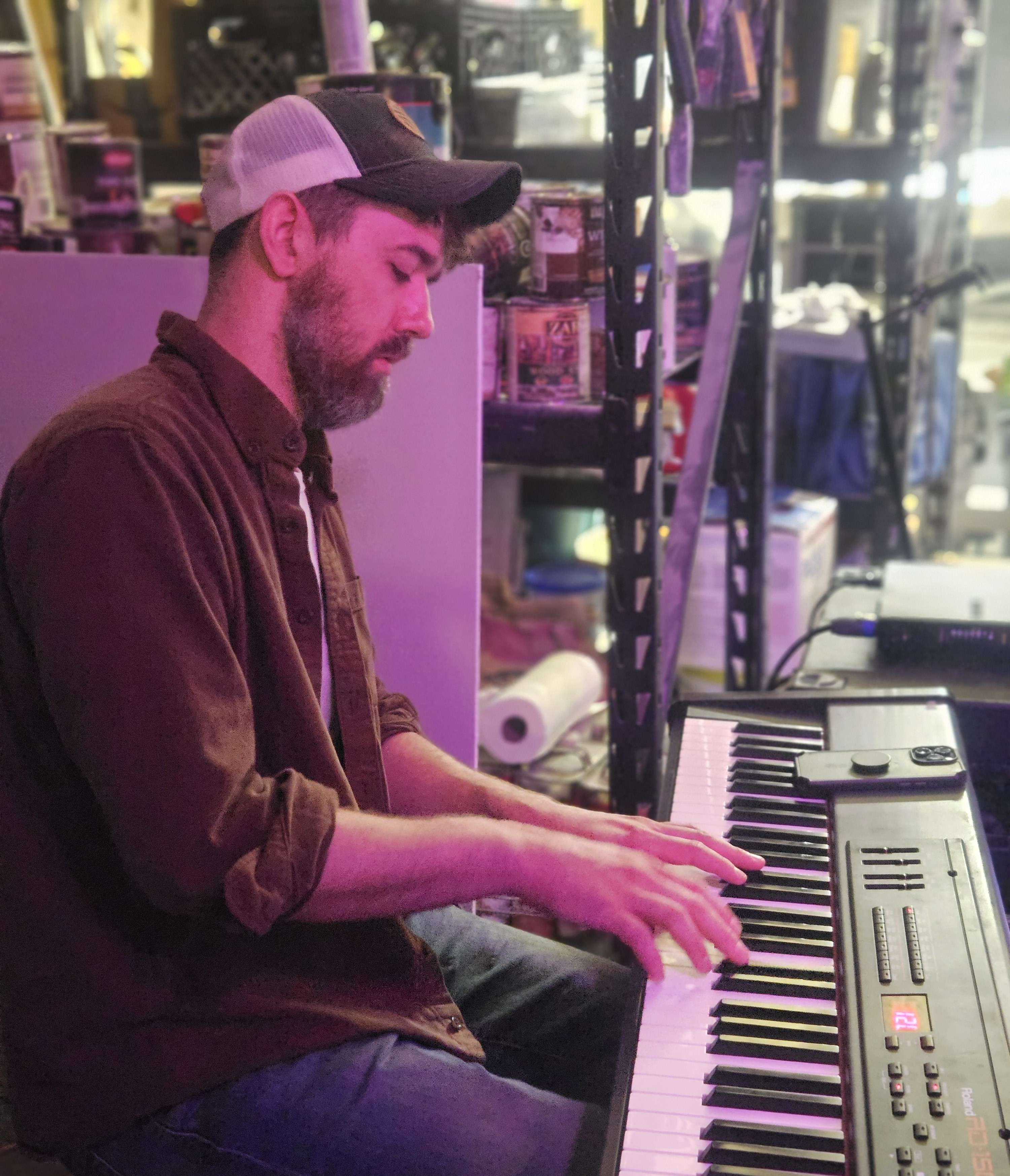 a man in a hat playing a keyboard in a store