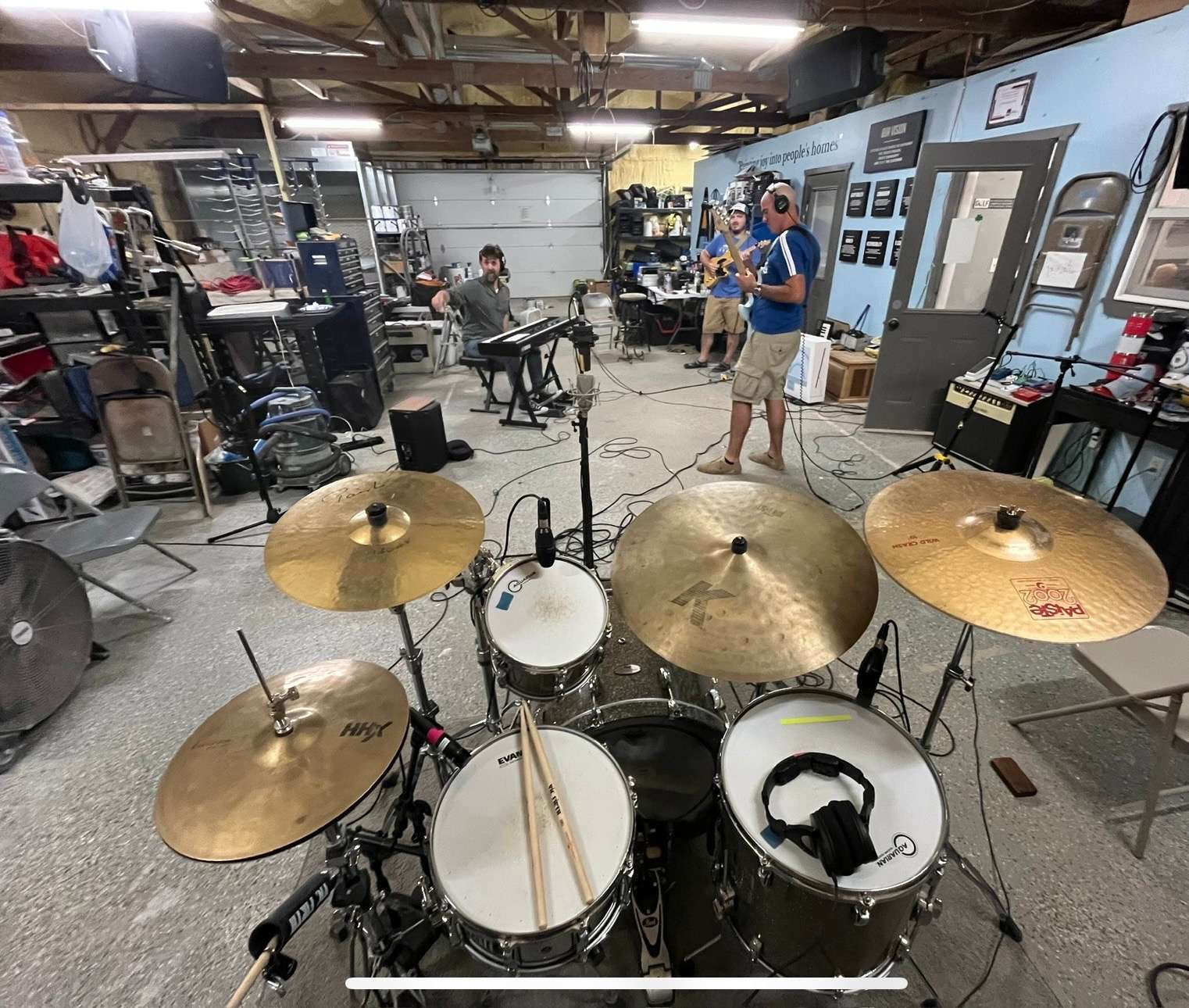 a group of people in a room with a drum set
