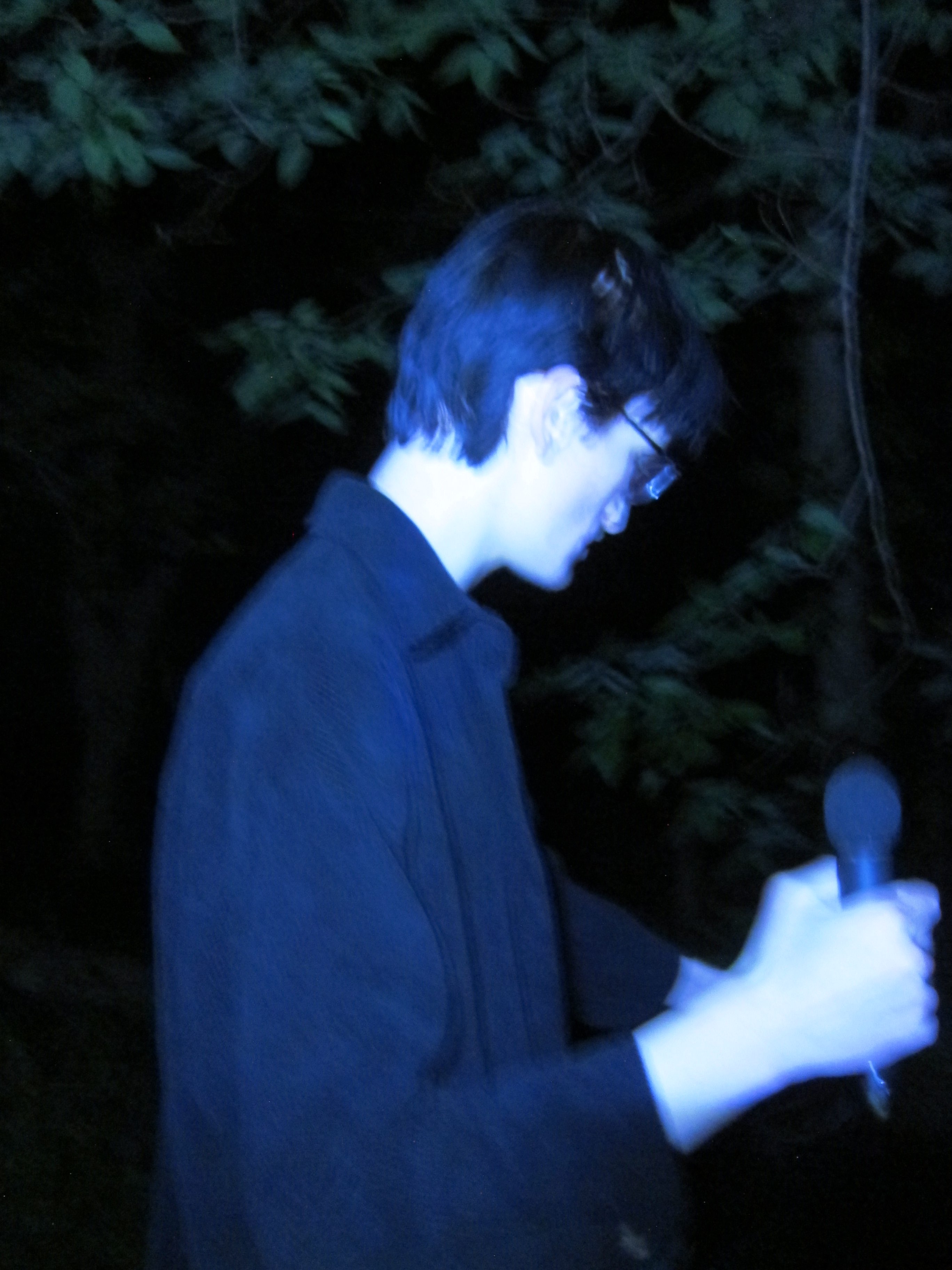 a man holding a microphone in the woods