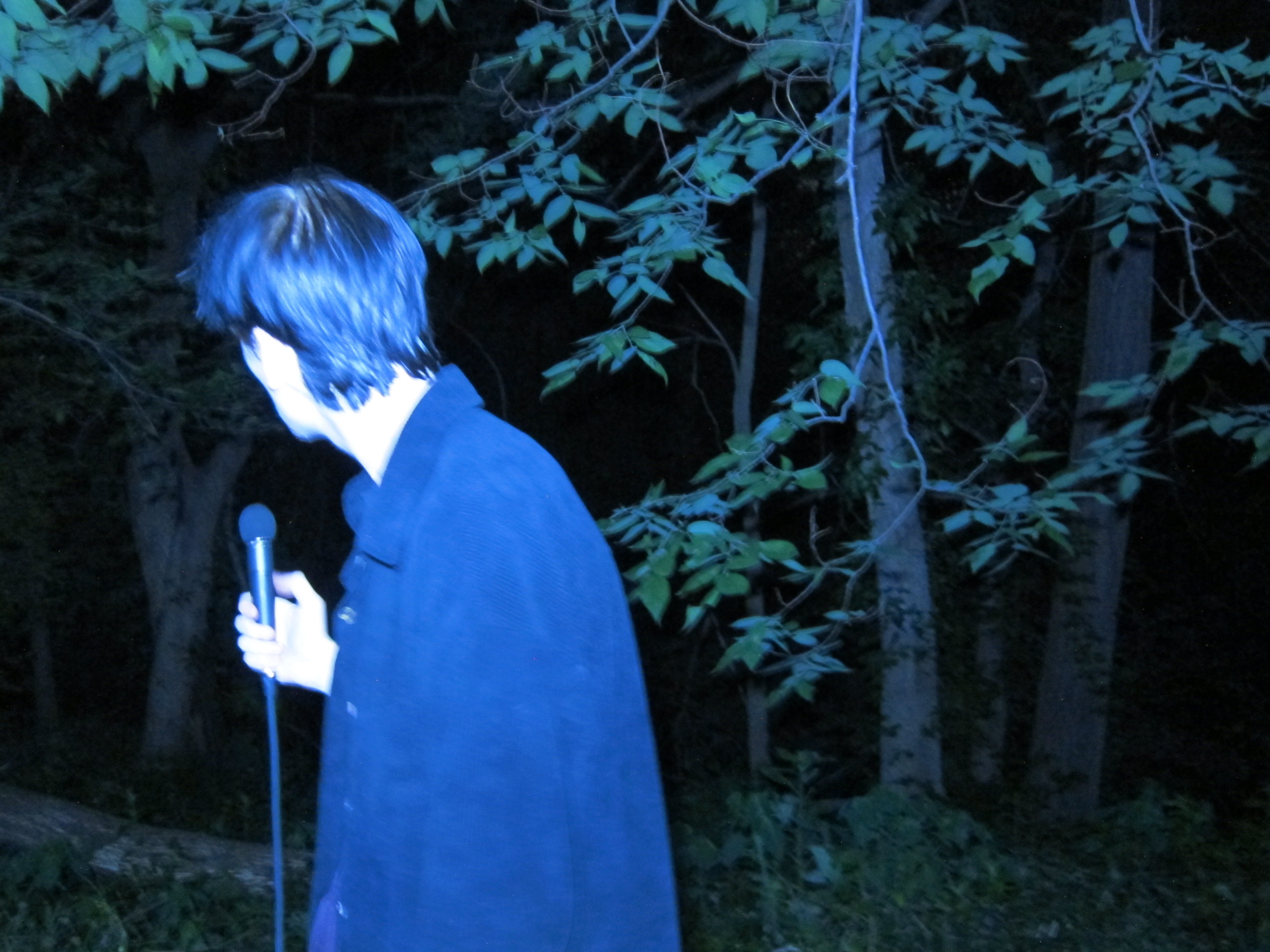 John California - Oblivion: a man standing in the woods holding a microphone