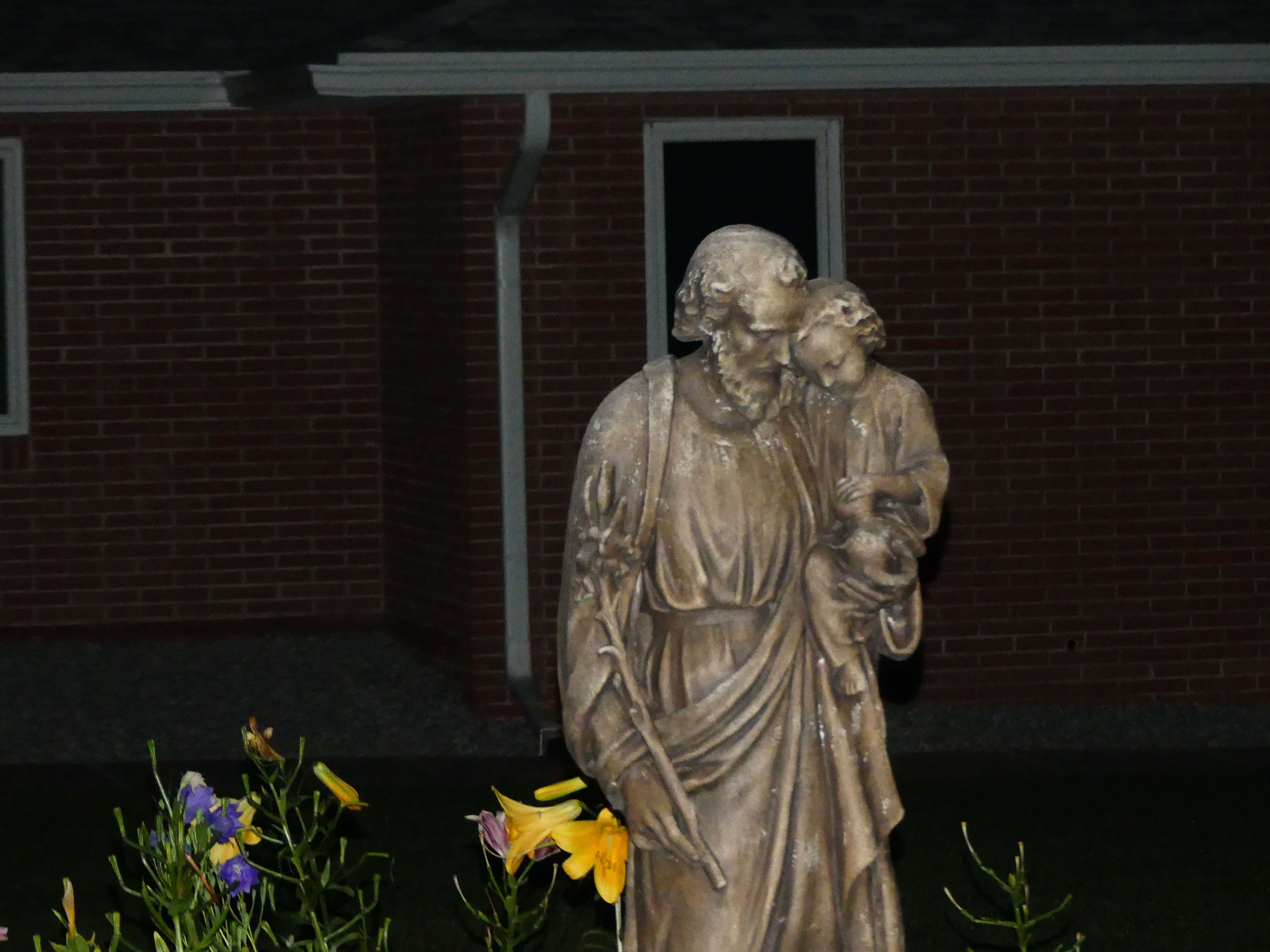 a statue of jesus in front of a house
