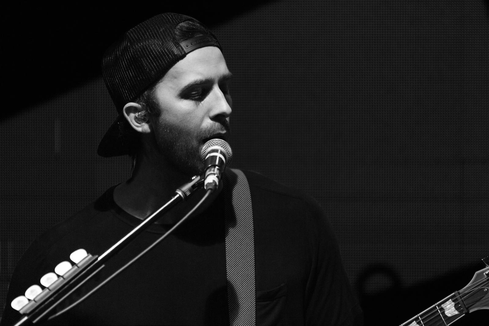a black and white photo of a man singing into a microphone