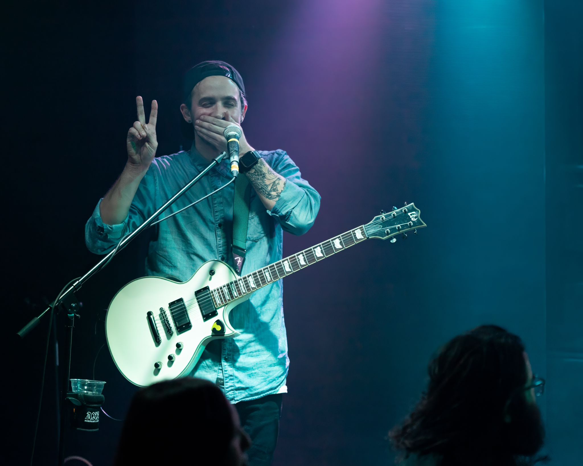 a man holding a guitar in front of a microphone