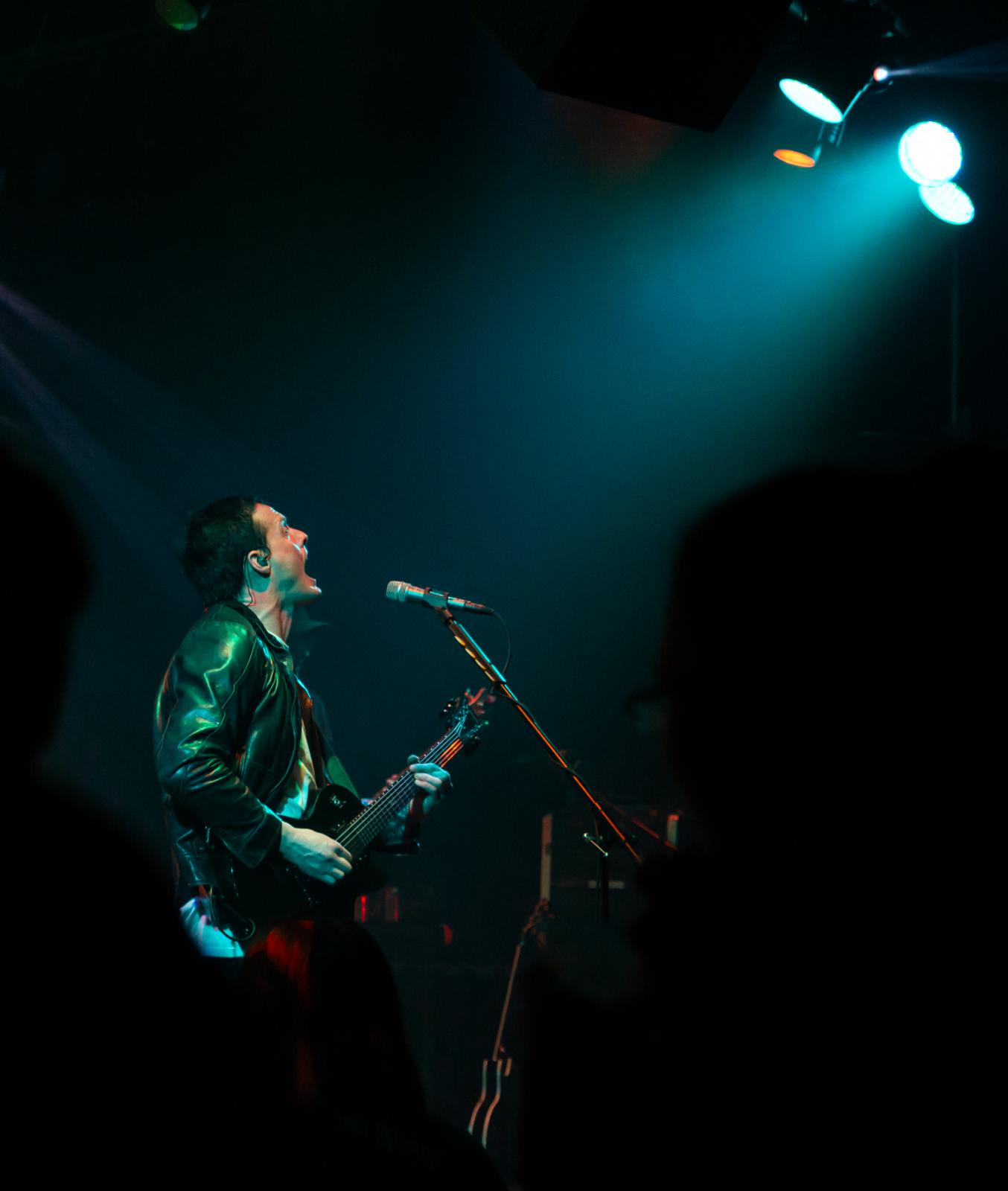 a man is playing a guitar on stage