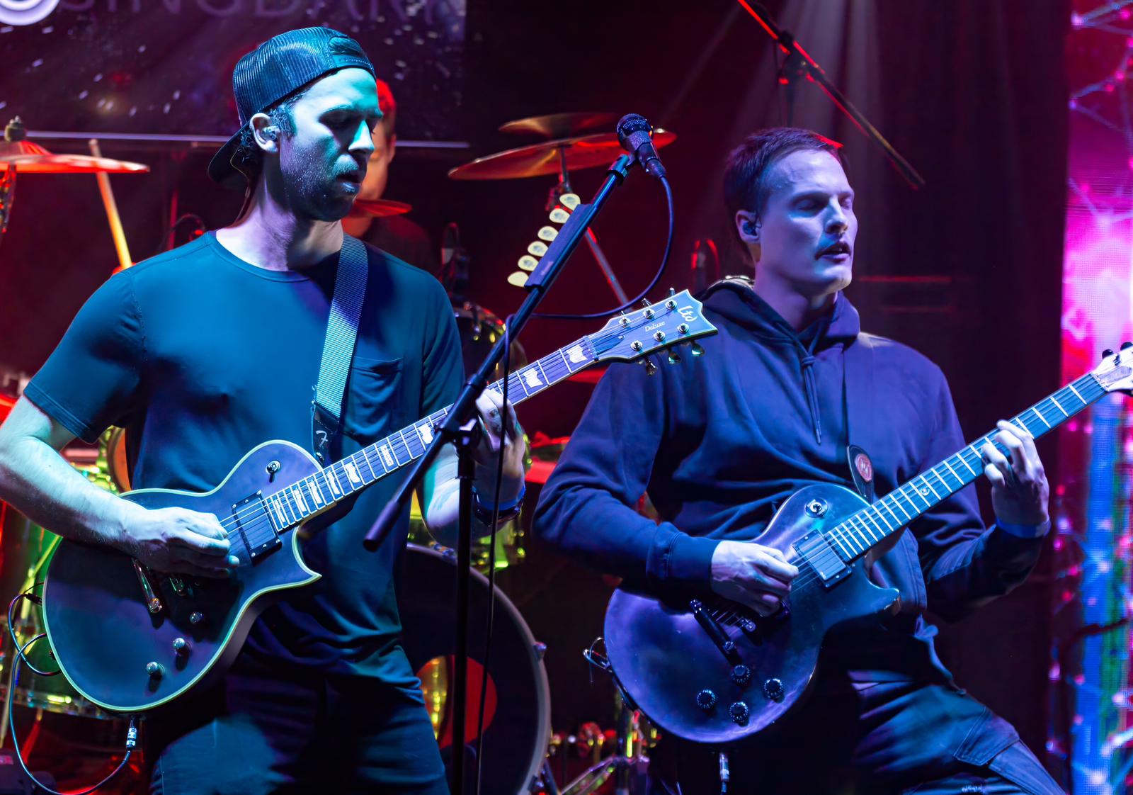 a group of men playing guitars on stage