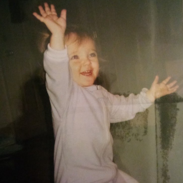 a young girl with her arms up in the air