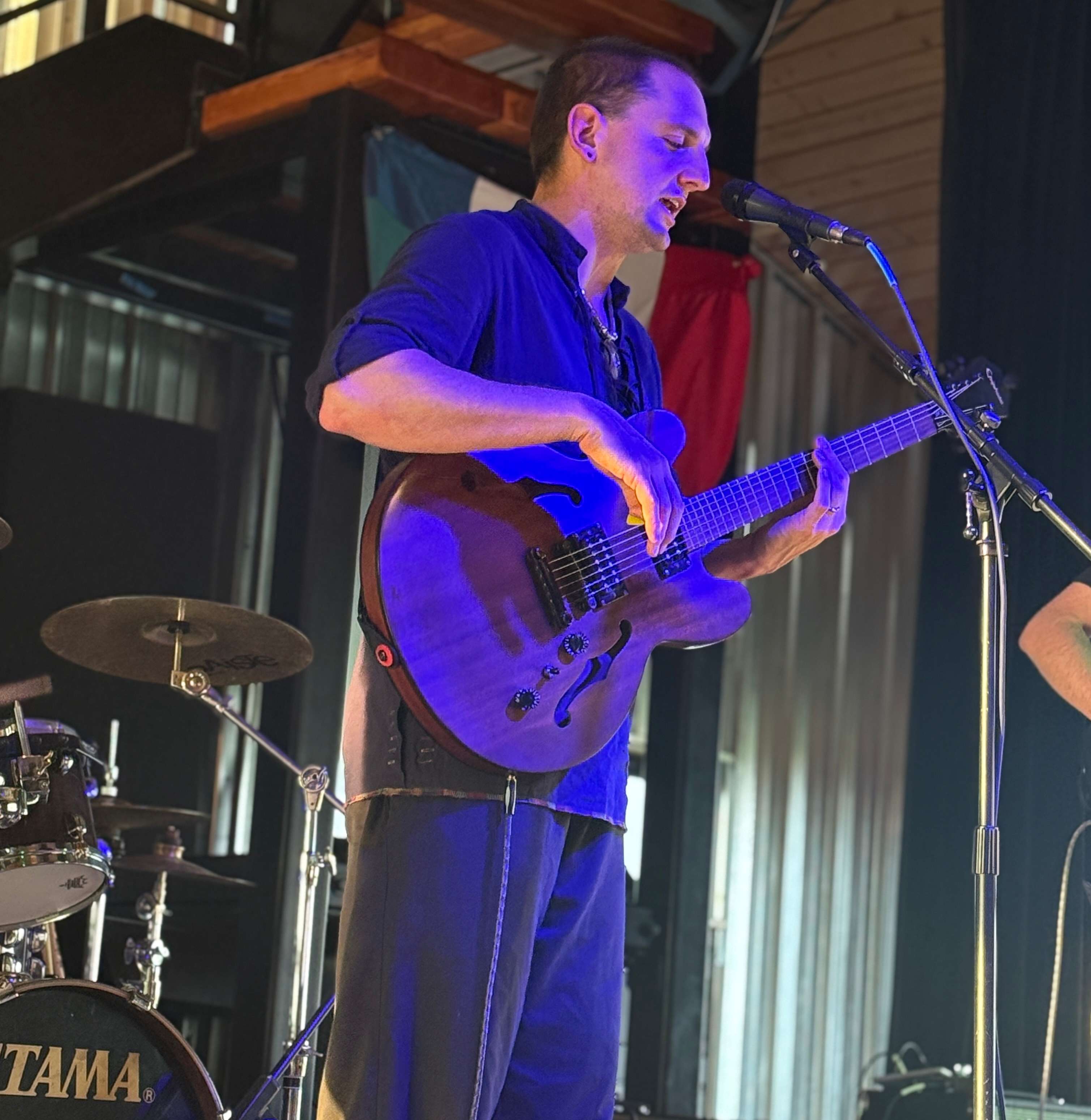 a man playing a guitar in front of a microphone
