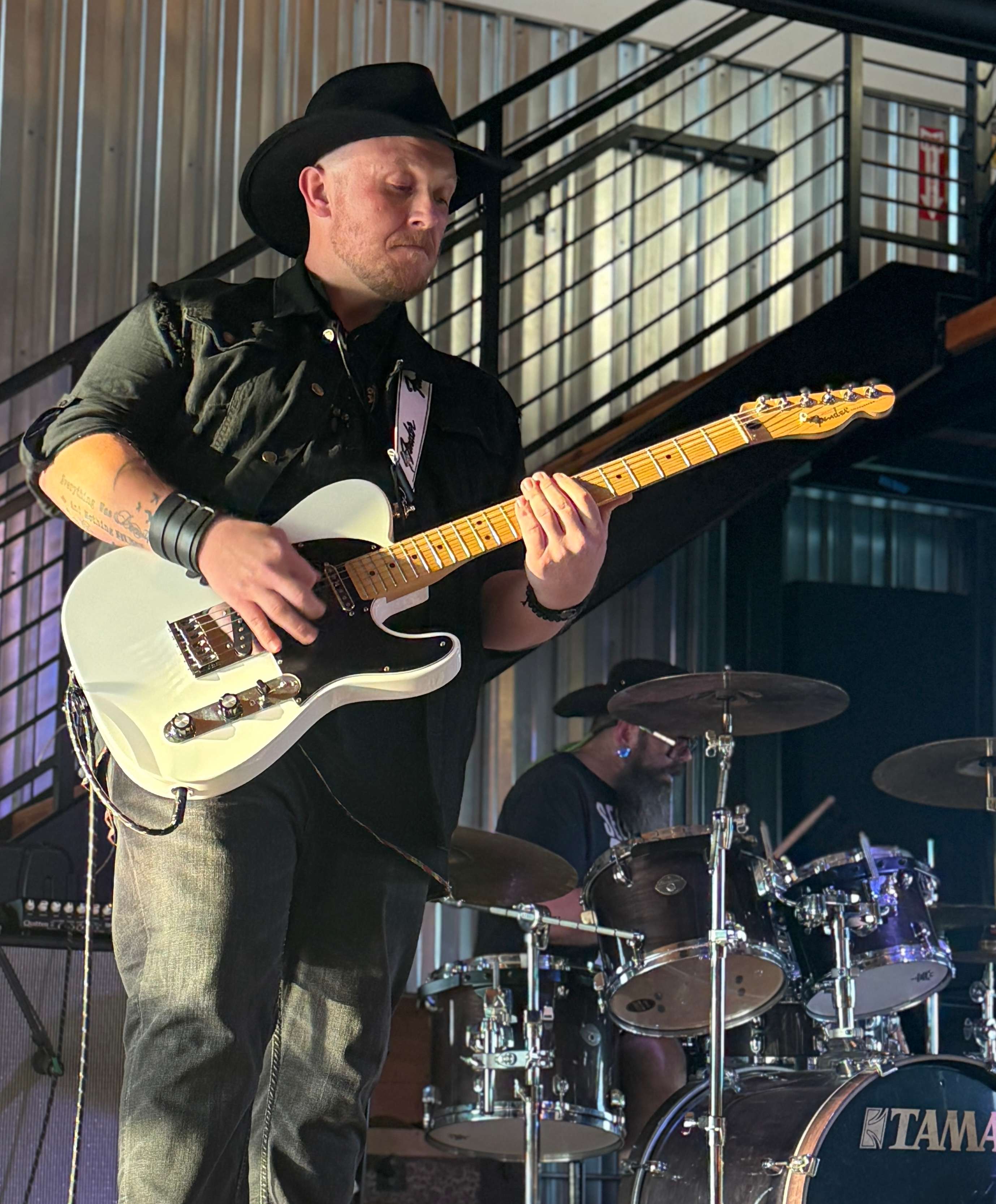 a man in a cowboy hat playing a guitar