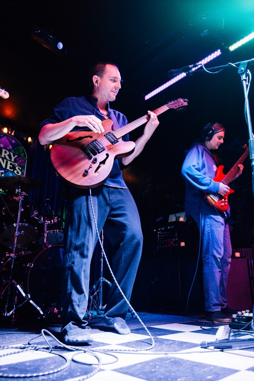 a group of men playing guitars on stage