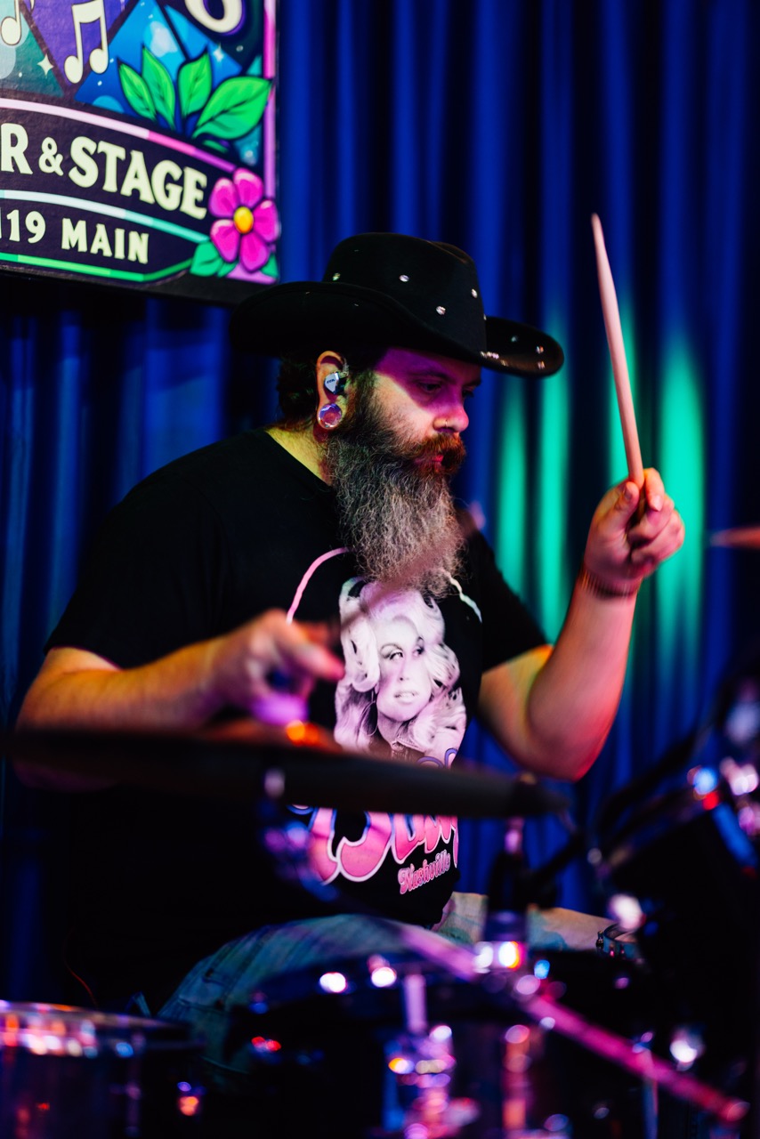 a man in a cowboy hat playing drums