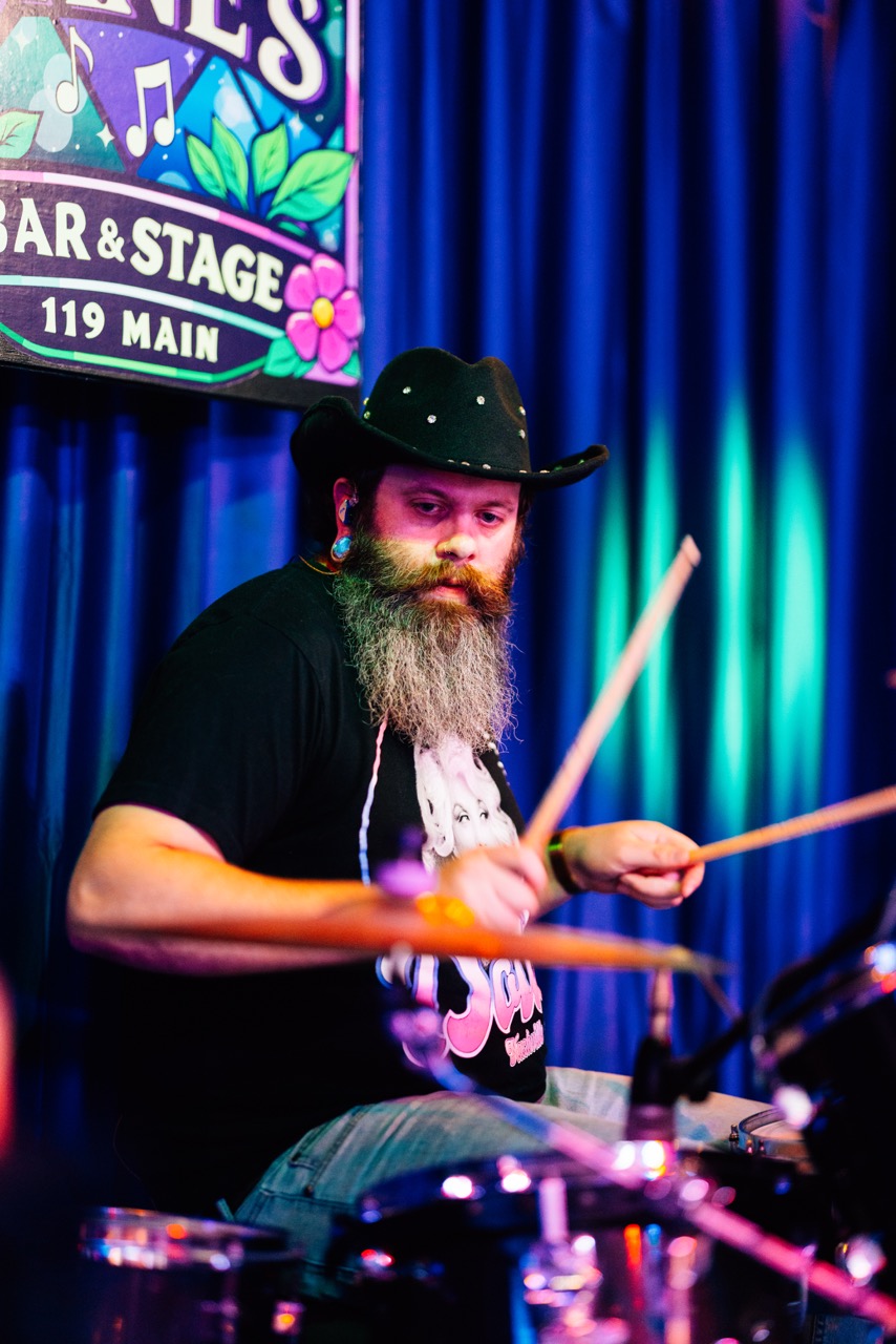 a bearded man with a beard playing drums