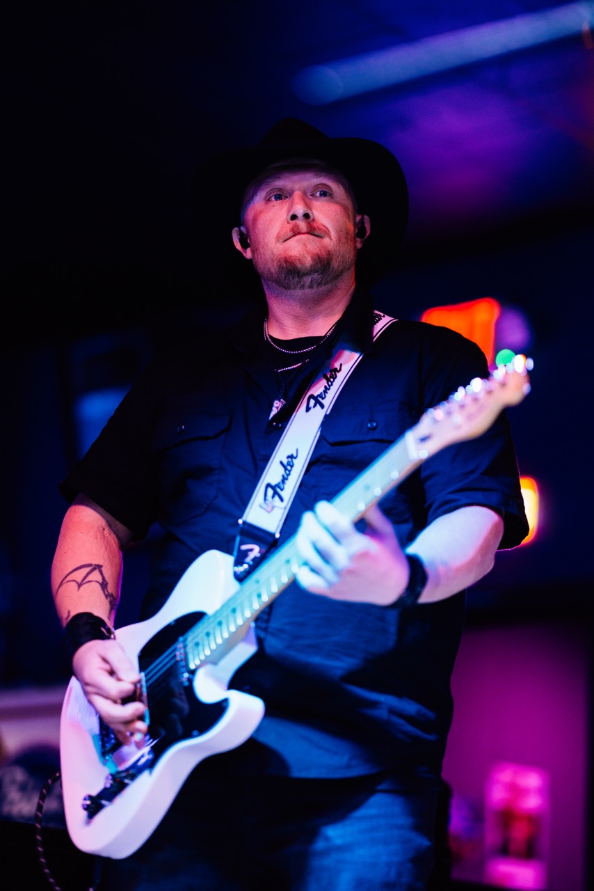 a man in a hat playing a guitar