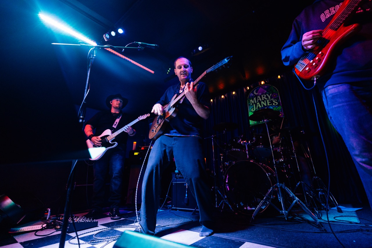 a group of people playing guitars on stage